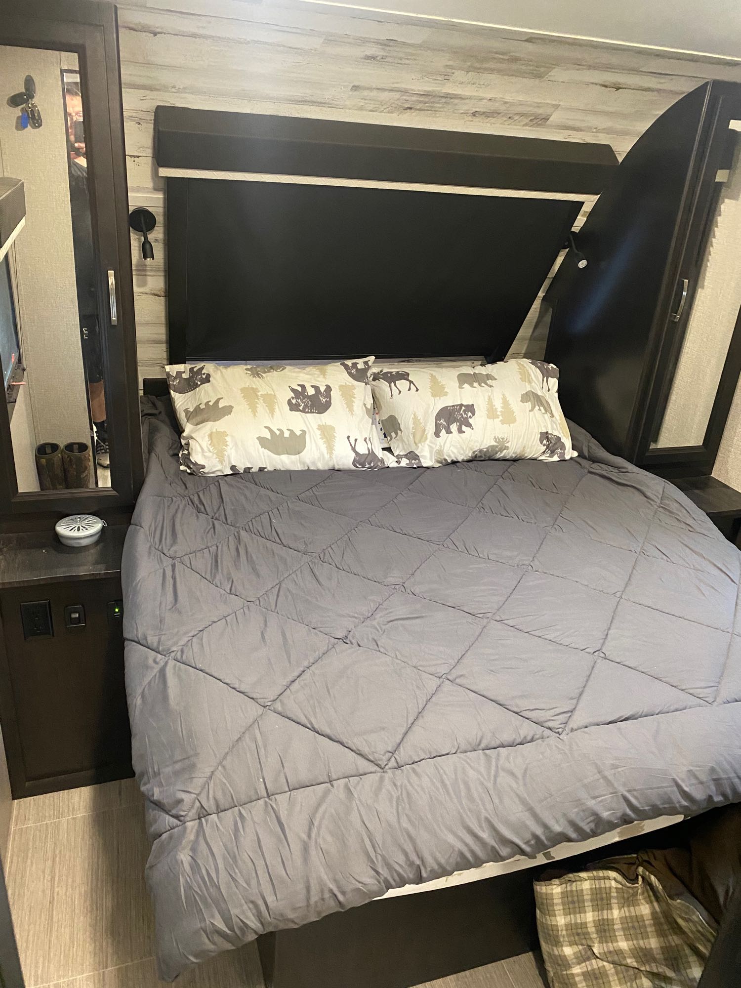 Cozy RV rental bedroom features a comfortable bed with grey comforter and playful bear-themed pillow.. Jayco White Hawk 2021