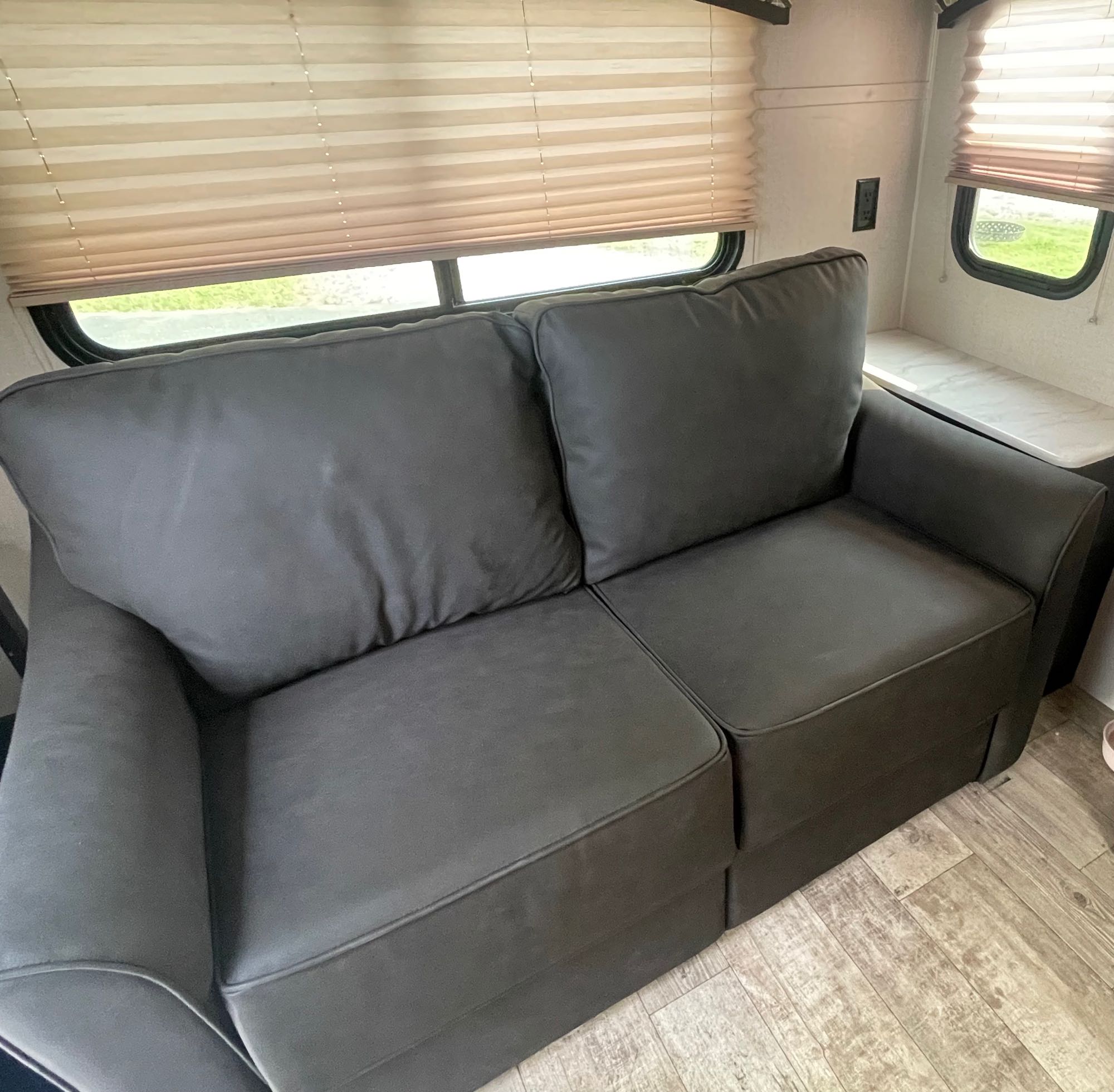 This RV rental showcases a comfortable dark gray sofa within its compact living space.. Venture RV Sonic 2020