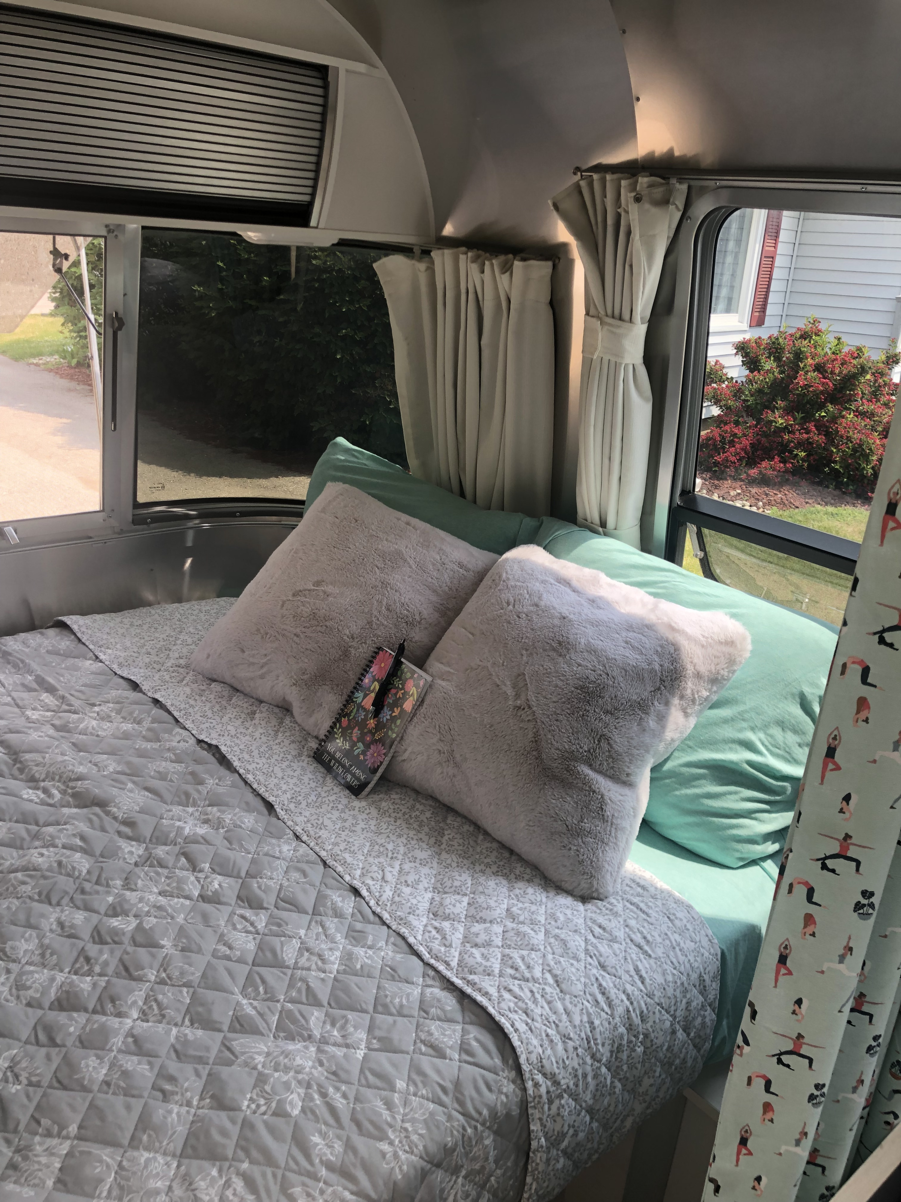 Cozy Airstream RV rental bedroom: plush pillows, quilted bed, light teal sheets, and windows with scenic views.. Airstream Sport 2019