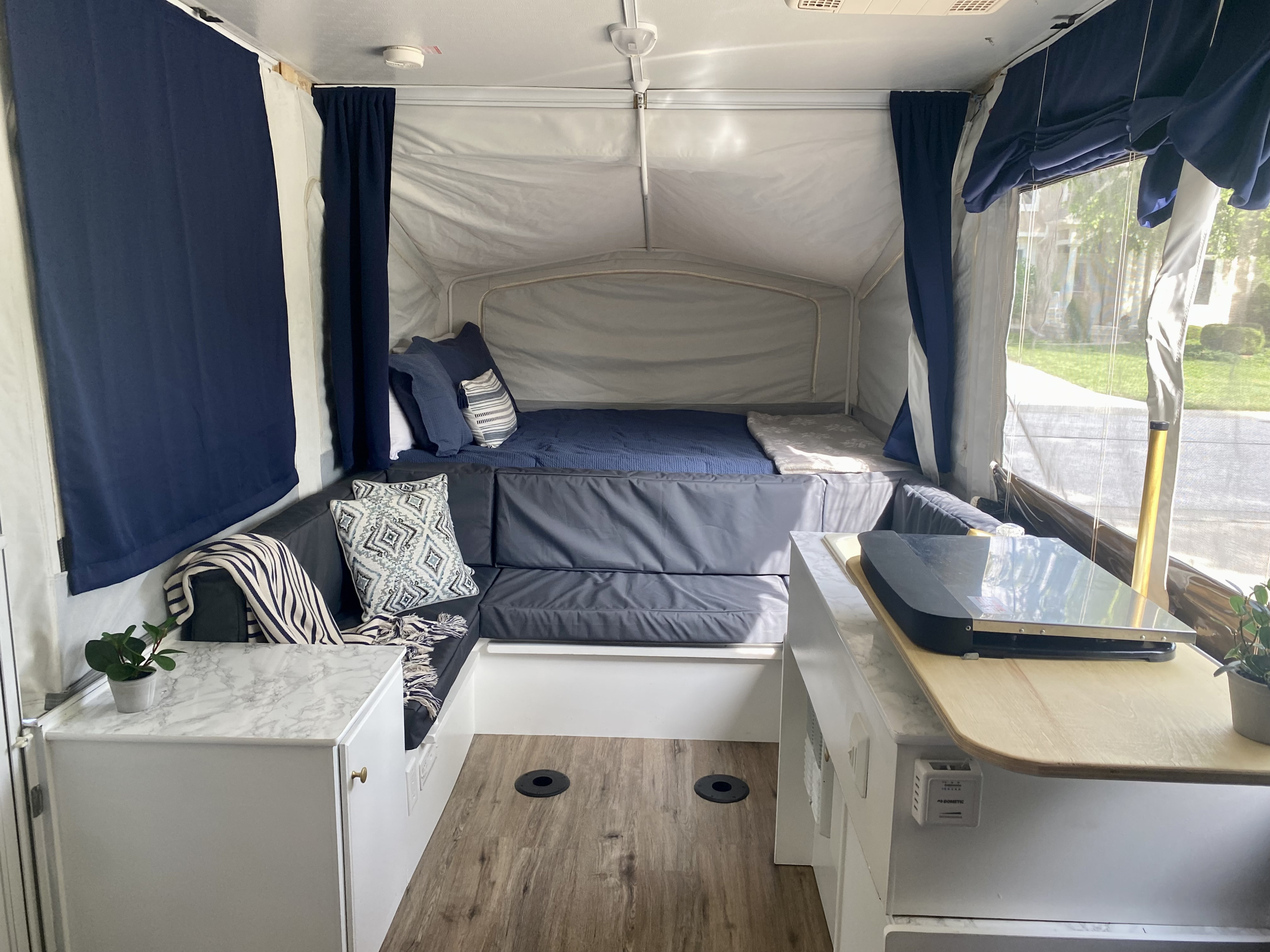 Bright, renovated pop-up camper interior showcasing a bed, L-shaped lounge, and kitchen counter for your RV rental trips.. Jayco Jay 2013