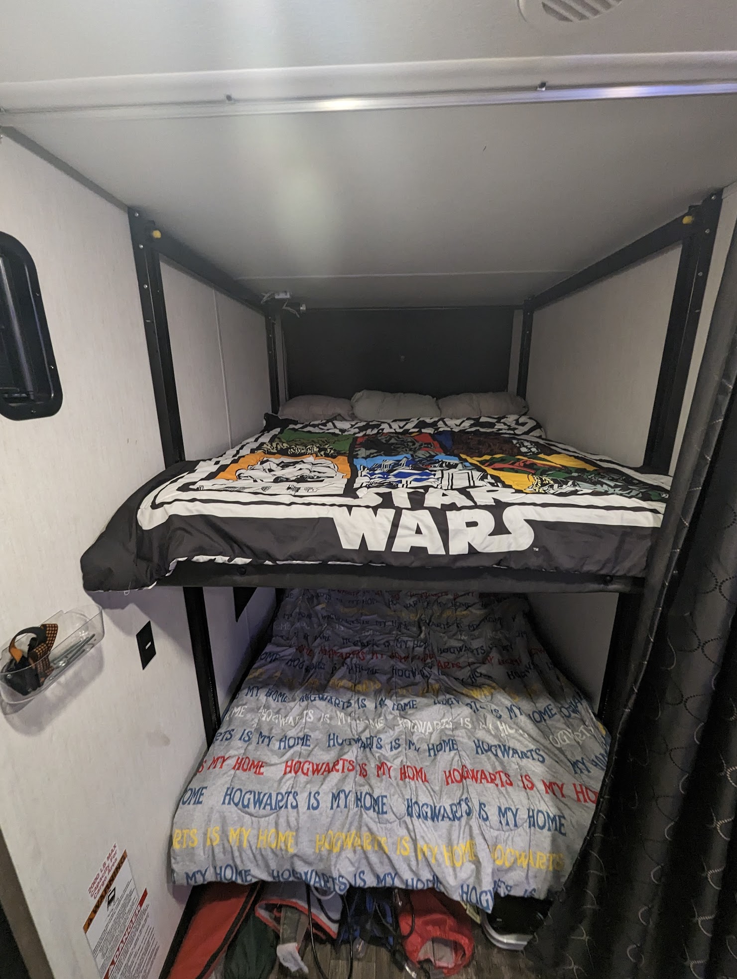 Cozy bunk beds in an RV rental, with Star Wars and Hogwarts bedding, ready for family travel and adventure.. Forest River Cherokee Wolf Pack Toy Hauler 2022