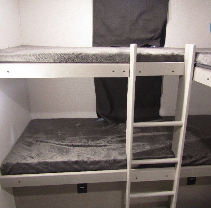 Experience comfortable sleeping arrangements in an RV rental with these bunk beds, complete with gray mattresses and privacy curtains.. Forest River Tracer 2021