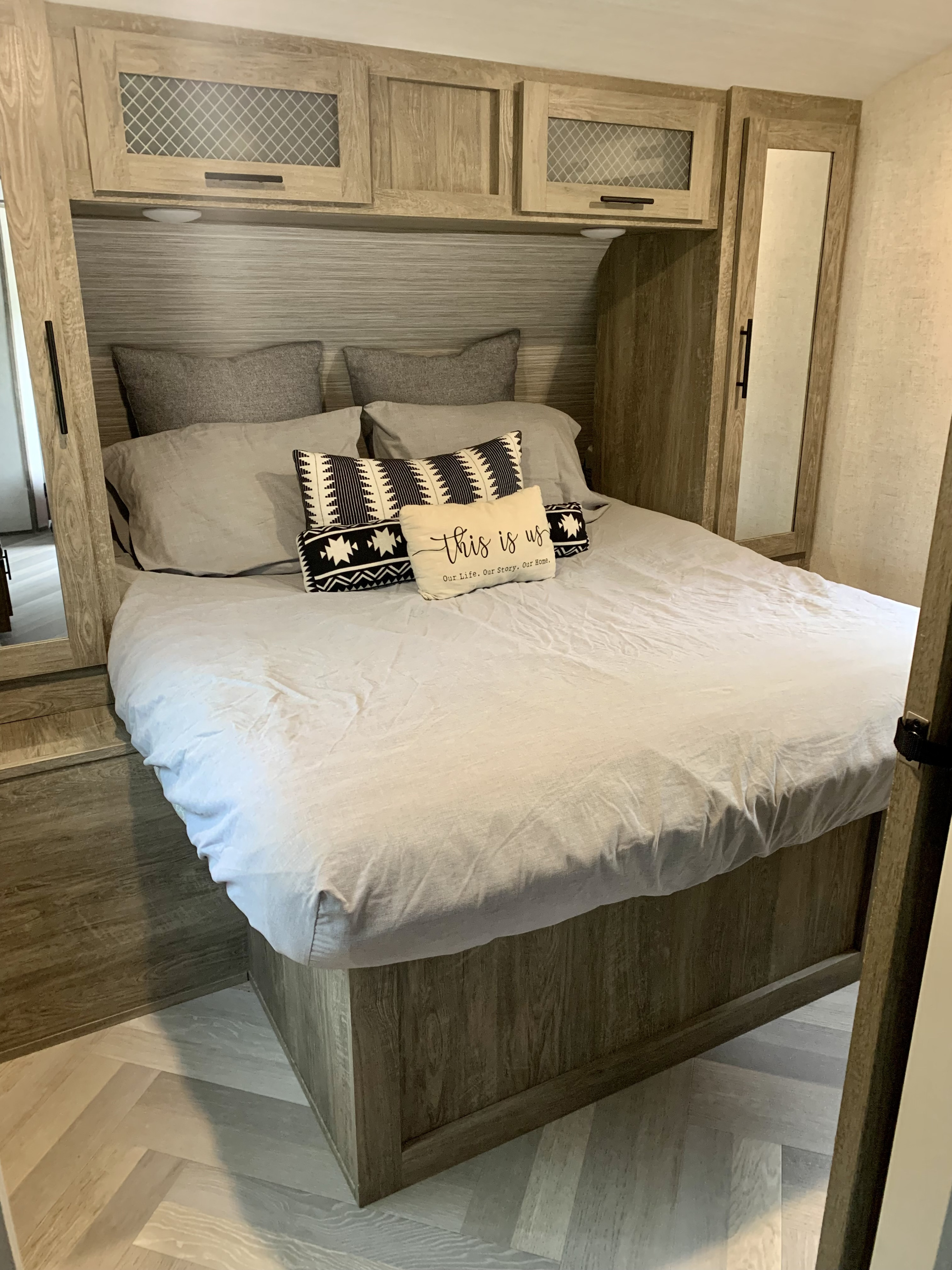 Cozy RV rental bedroom: light wood interior with a comfy bed, overhead storage, and herringbone floor.. Forest River Salem Hemisphere HL 2021