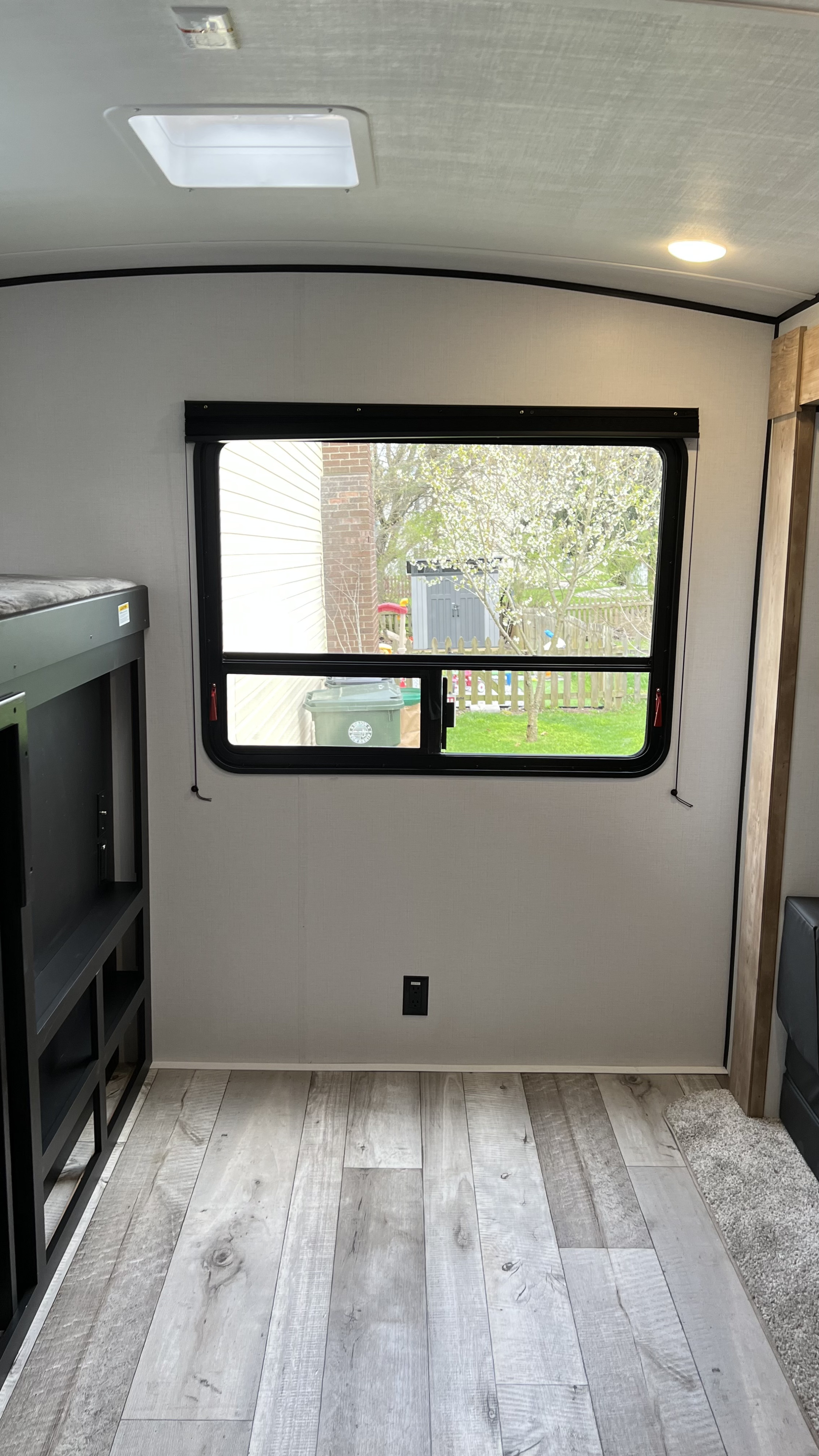 RV rental interior: bunk beds left, large window with outdoor view, light wood-look flooring.. Keystone RV Springdale 2022
