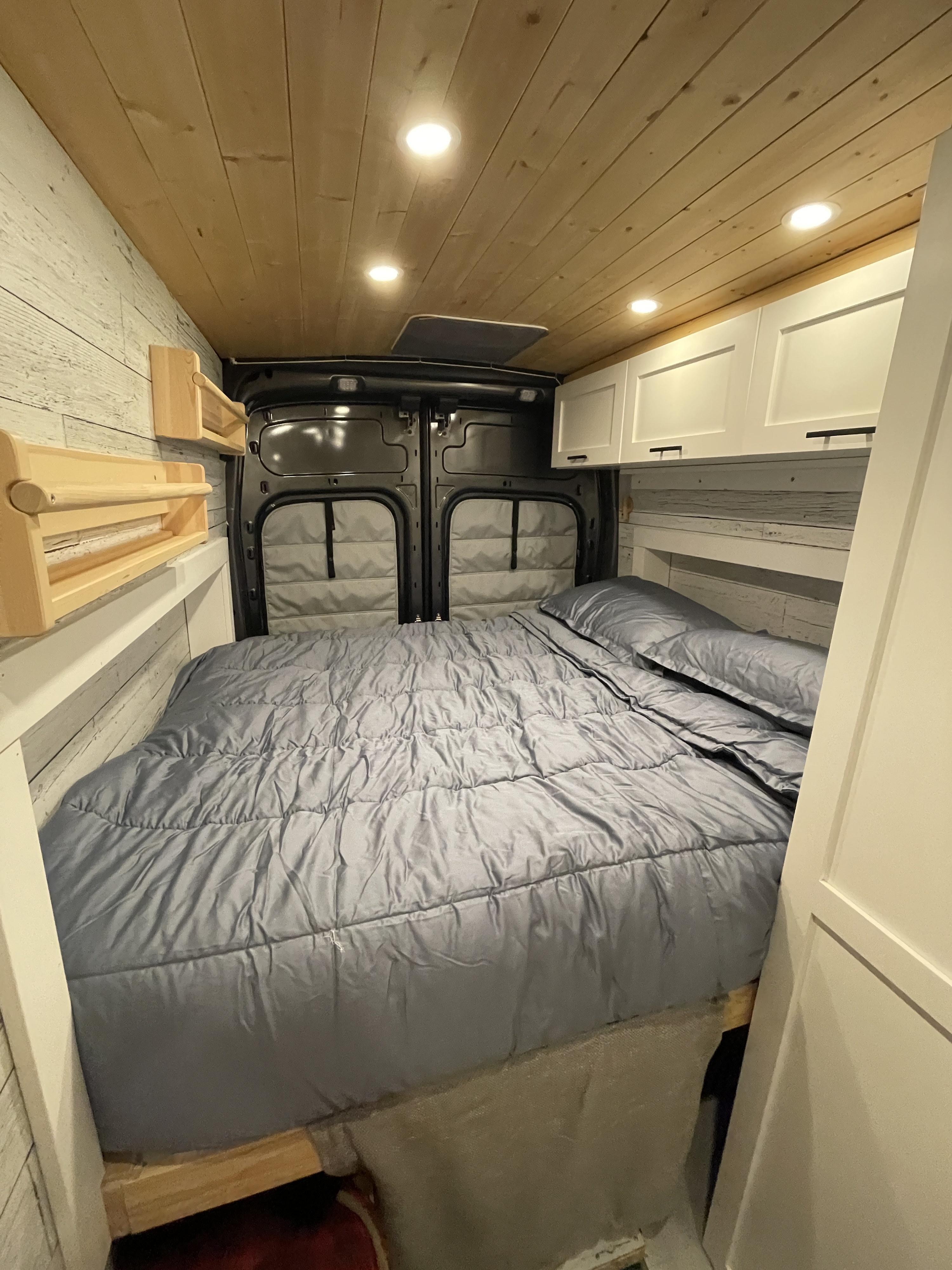 RV rental: Cozy camper van interior with bed, wood walls, ceiling lights, storage shelves & cabinets.. Ford Transit Custom 2019