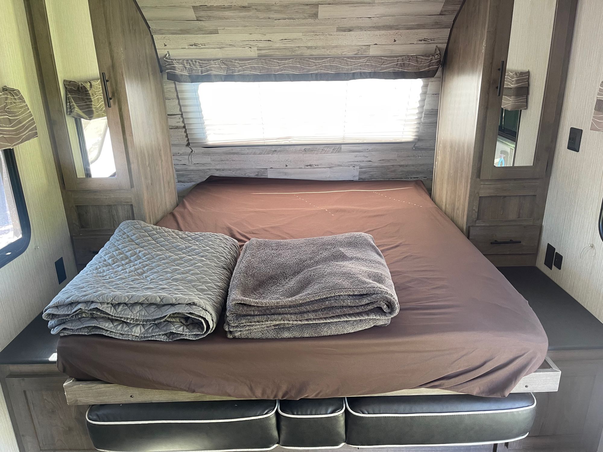 Cozy RV rental bedroom with a comfortable bed, folded blankets, and built-in storage. Ideal for travel trailer adventures.. Palomino Palomino puma xle lite 23fbc 2020