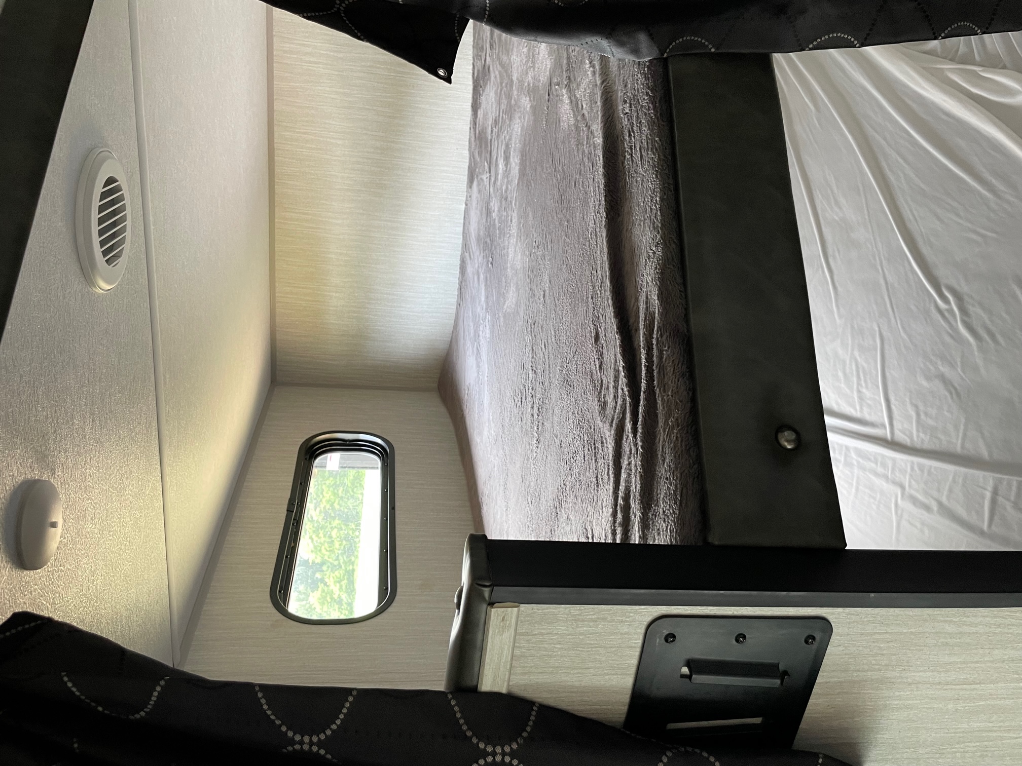 RV rental interior: A cozy bunk bed area with a small window, air vent, and comfortable bedding.. Forest River Cherokee Grey Wolf 2020