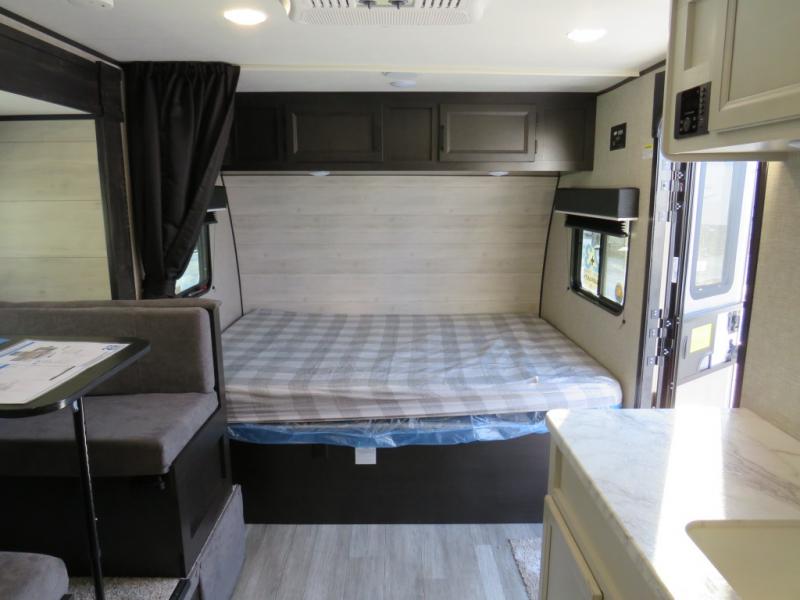 RV rental interior featuring a comfortable bed and dining area, with ample overhead storage.. Jayco Jay Flight SLX STX Edition 2023