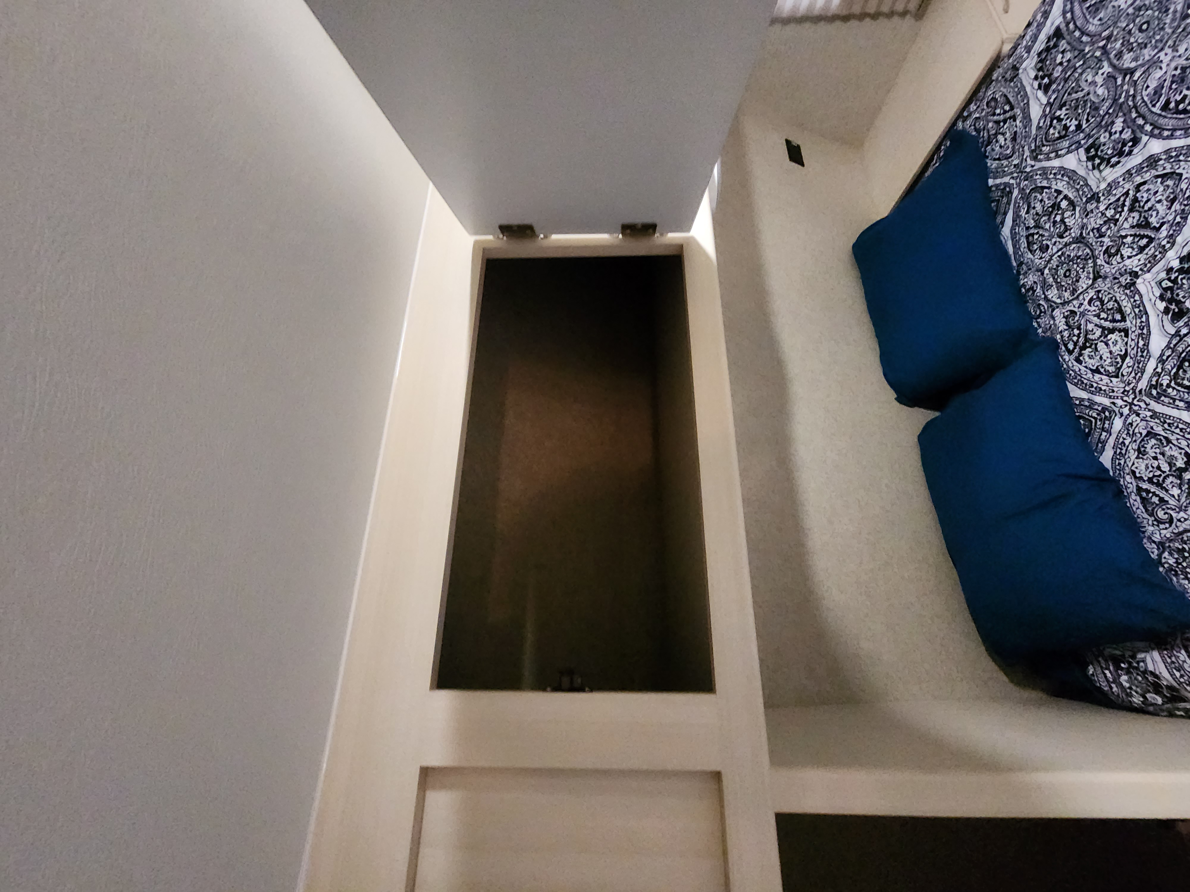 Looking down into an open storage compartment next to a bed in an RV rental.. Minnie Minnie Trailer 2017