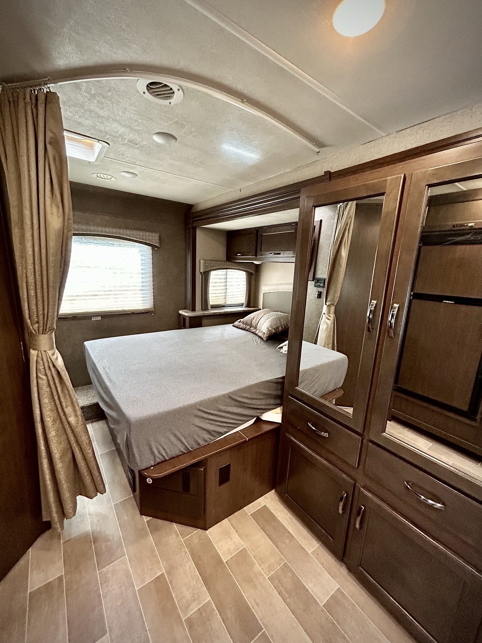 Spacious RV rental bedroom featuring a comfortable bed, mirrored wardrobe, and modern interior design.. Thor Chateau 2020