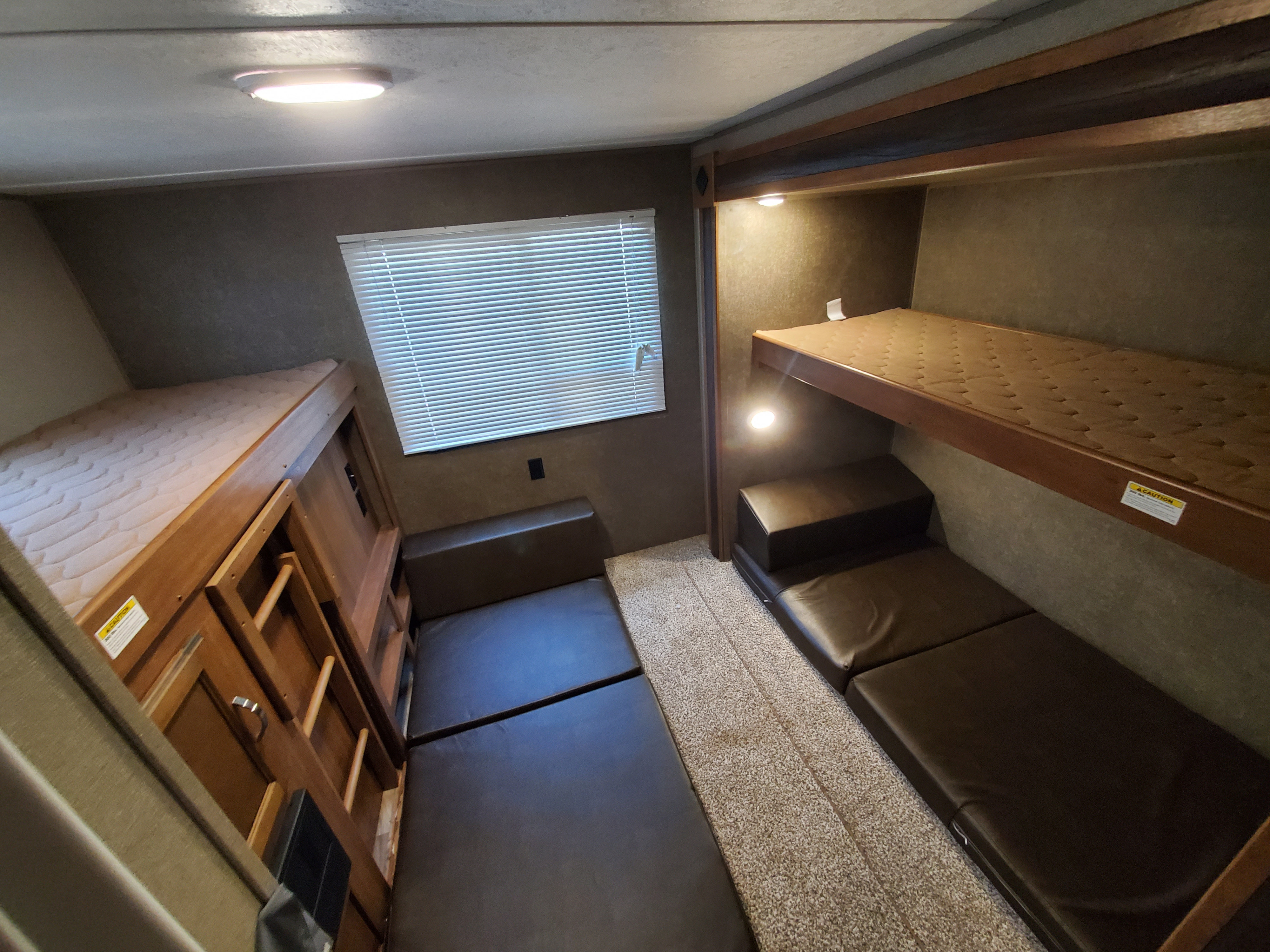 Experience comfort in this RV rental bunkhouse: multiple bunk beds, convertible seating, a window, and cozy lighting.. Keystone Springdale 2018