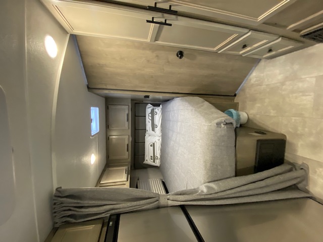 Bright RV rental bedroom showcasing a comfy bed with camper pillows, wood cabinets, and window. Ideal for travel.. Forest River Coachmen Cross Trail XL 2022
