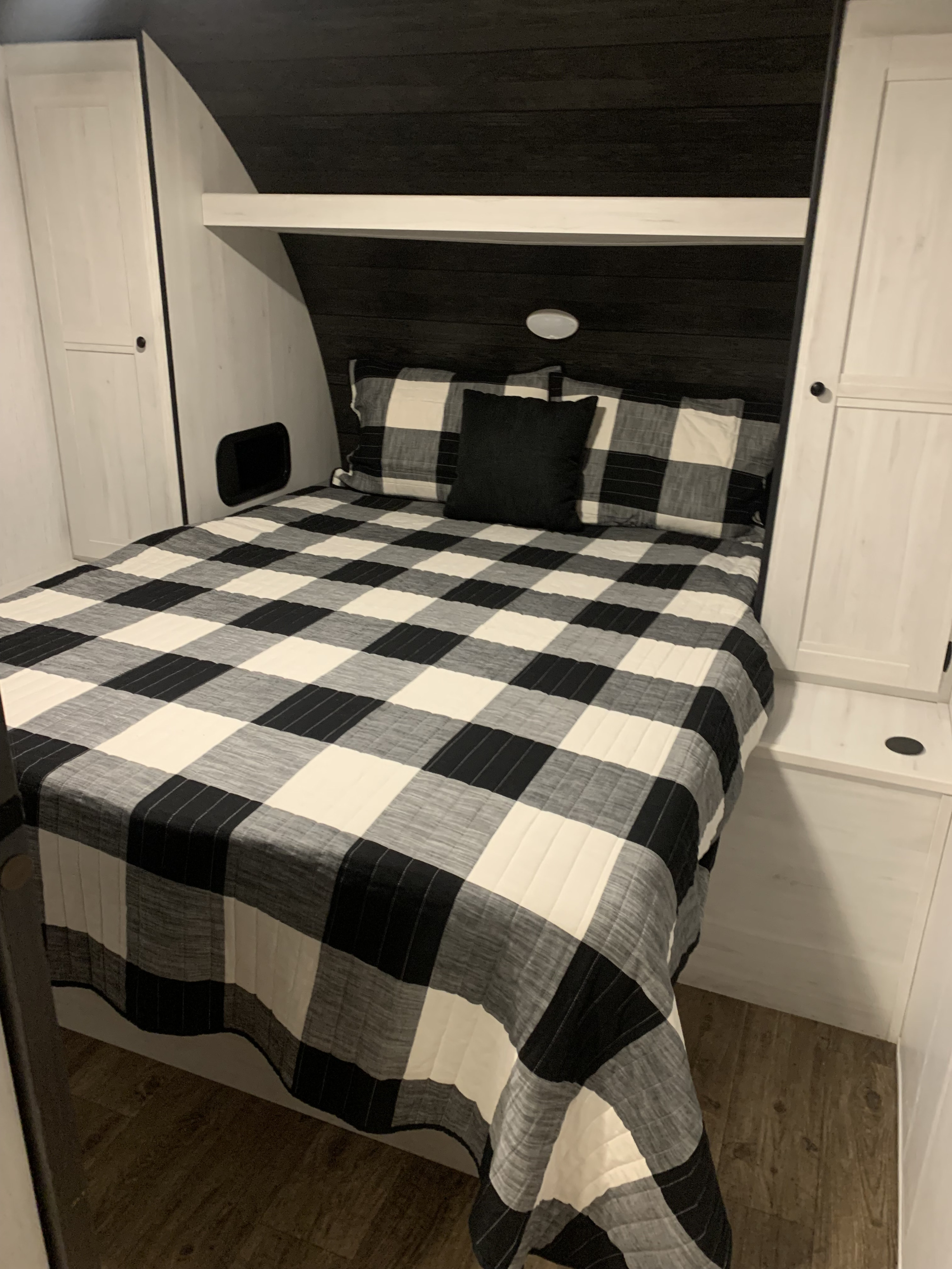 Inviting RV rental bedroom featuring black & white buffalo plaid bedding and ample built-in storage.. Heartland RVs Trail Runner 2022