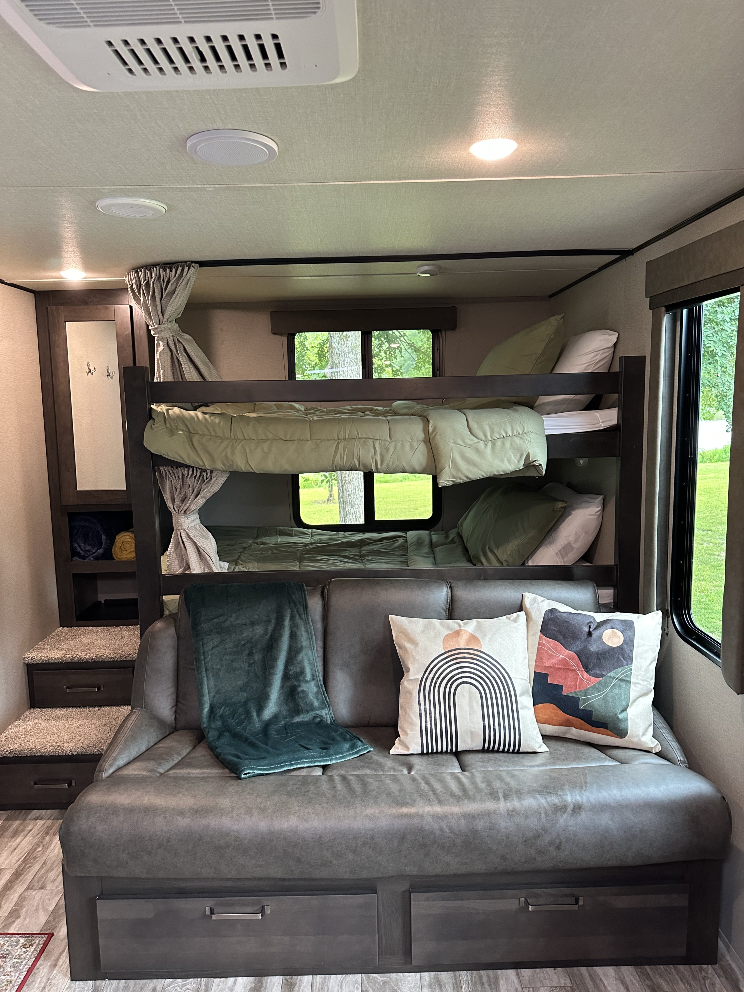 Cozy RV rental interior with bunk beds, comfortable sofa, and storage. Perfect for family adventures in a travel trailer.. Grand Design Transcend Xplor 2022
