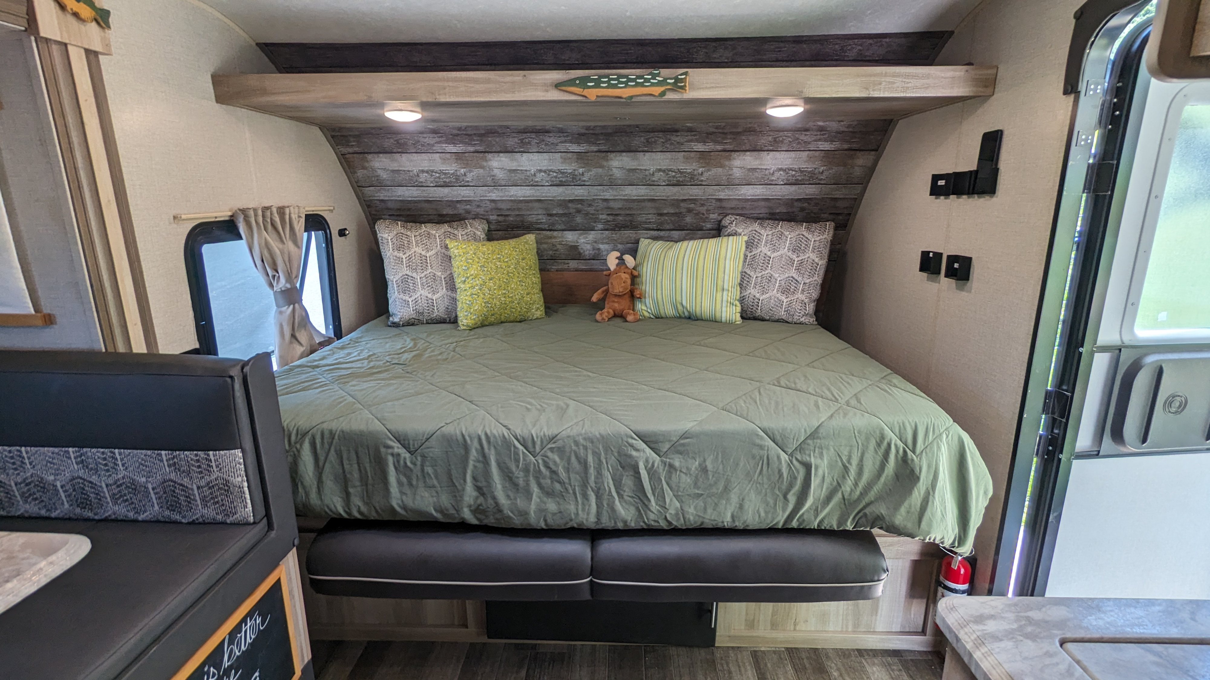 This cozy RV rental features a full bed with green comforter, decorative fish, and a dinette. Ideal for travel!. Forest River Other 2021