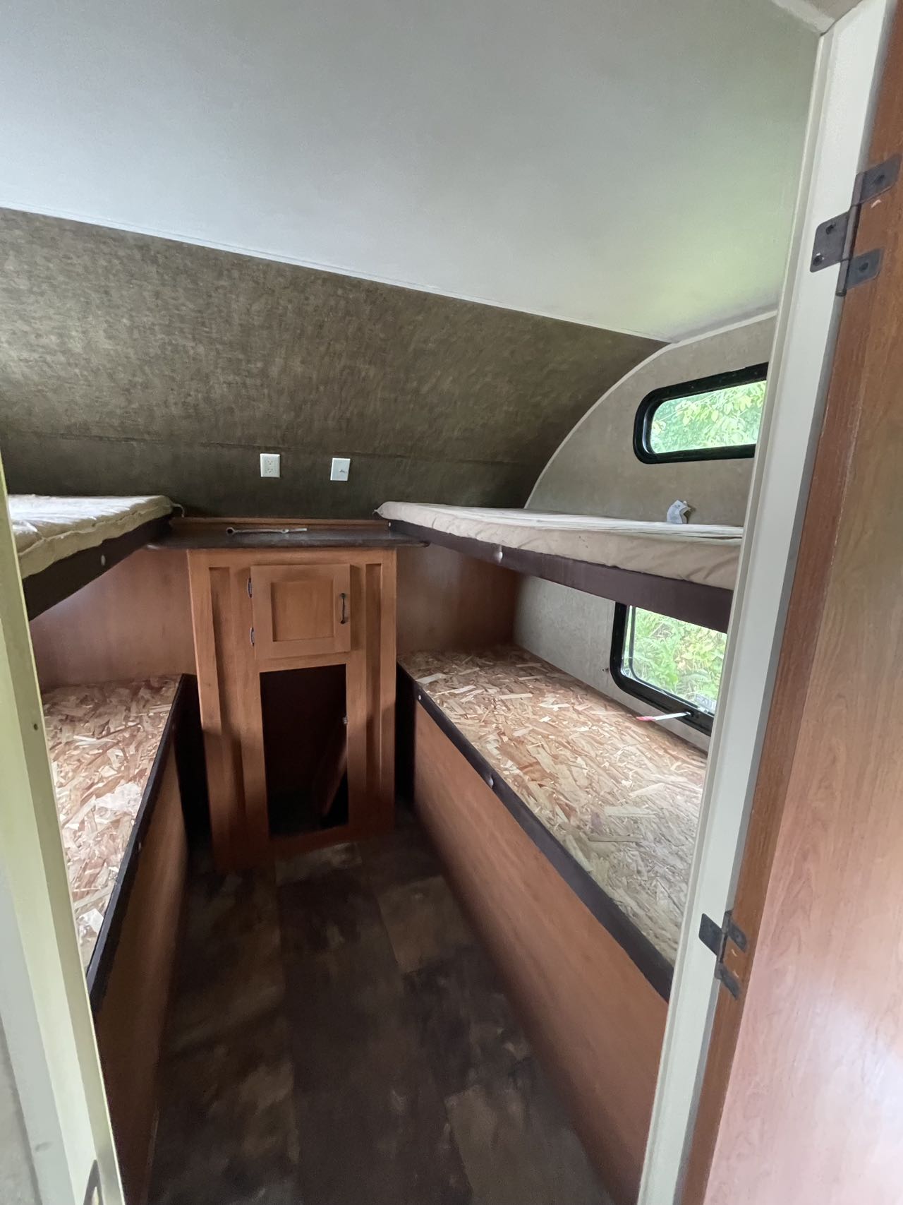RV rental bunkhouse interior with upper mattresses and lower bare bunks, plus central storage. Perfect for family adventures.. Forest River Cherokee Grey Wolf 2015