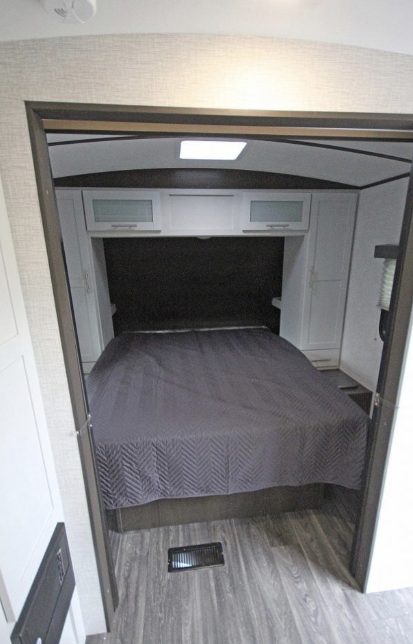 This RV rental bedroom offers a comfortable bed, overhead storage, and cabinets. A skylight brightens the space.. Keystone RV Bullet Ultra Lite 2021