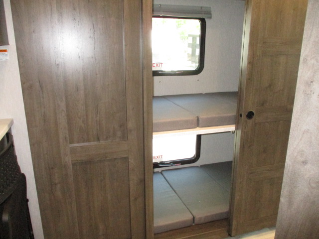 RV rental interior with two bunk beds, complete with cushions and windows for natural light and comfort.. Coachmen Mirada 2024