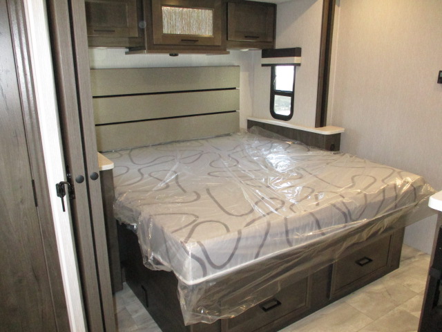 RV rental bedroom with a covered bed, built-in headboard, and under-bed storage. Ready for your journey.. Coachmen Mirada 2024