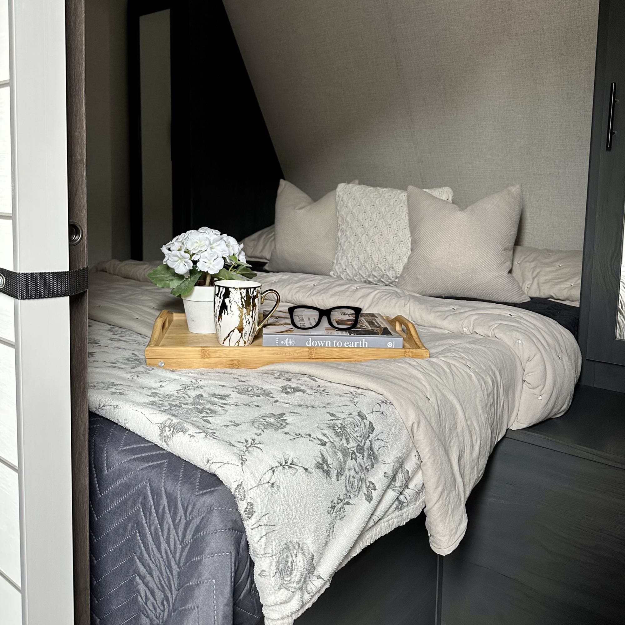 Explore this inviting RV rental bedroom setup with soft bedding, a ready-to-read tray, and smart storage.. Dutchmen Aspen Trail 2022