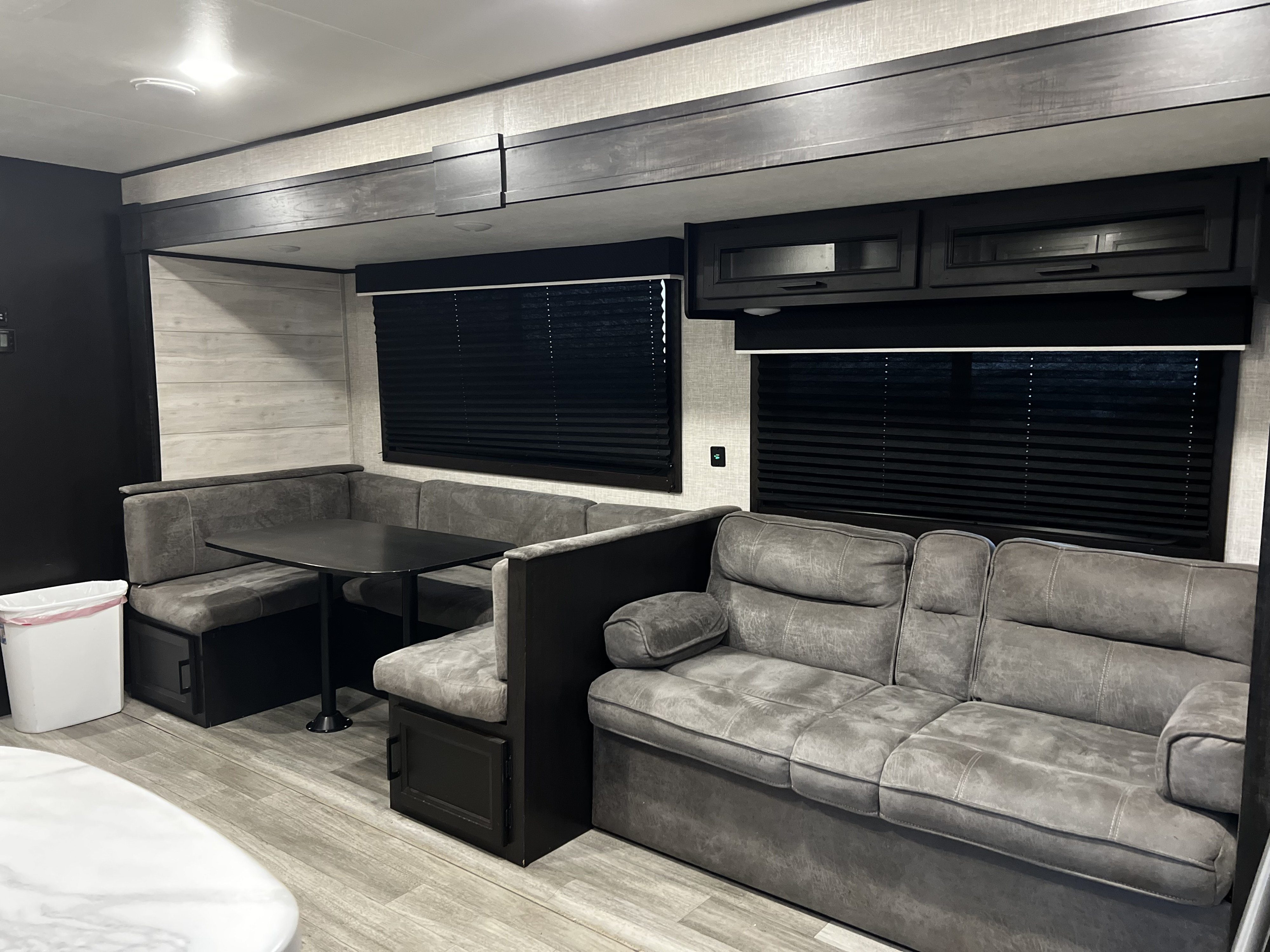 Explore this RV rental's cozy living area with a plush dinette and sofa, offering comfortable travel.. Jayco Jay Flight 2023
