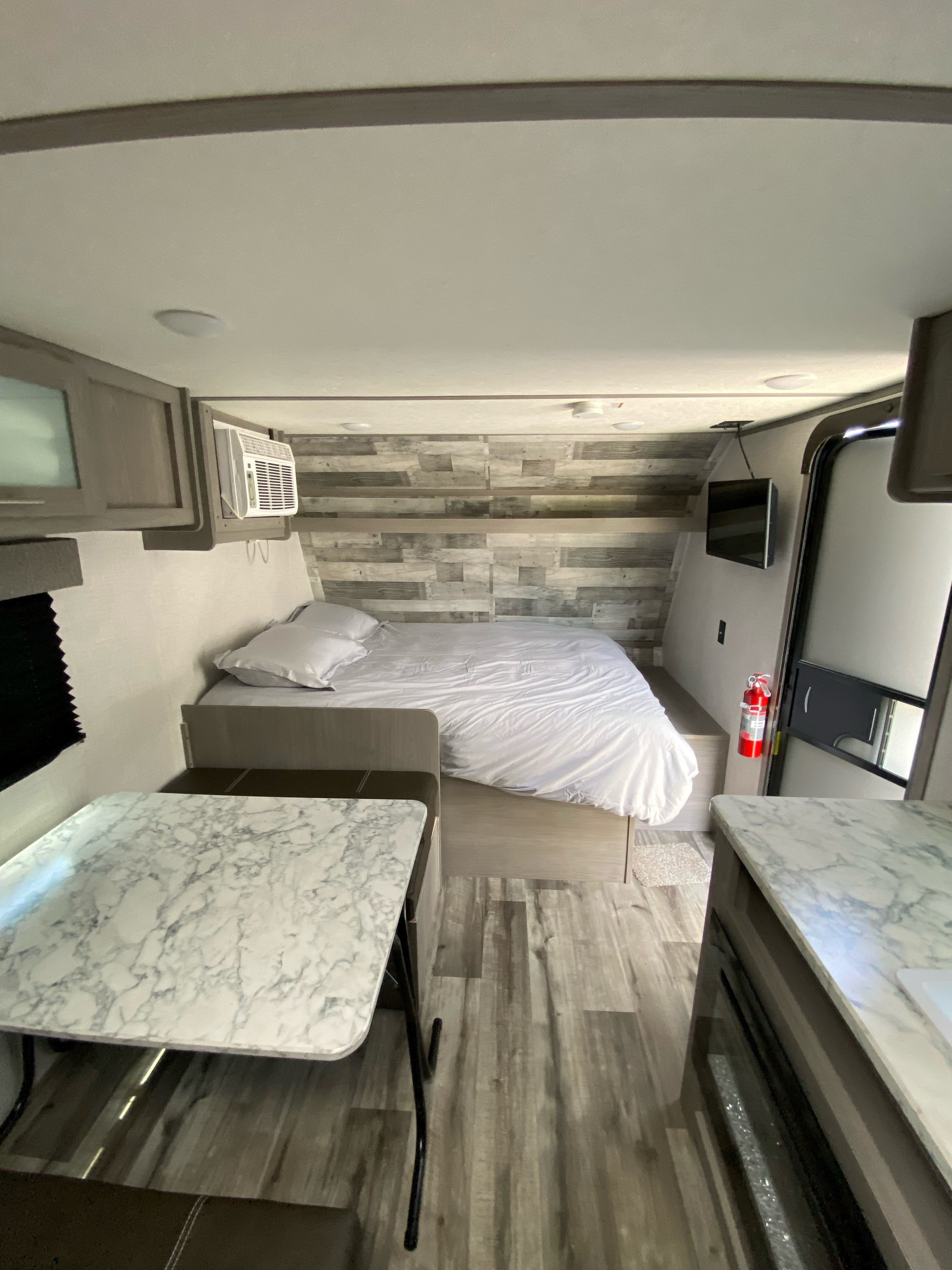 Inside this spacious RV rental: a comfortable bed, dinette, AC, and TV. Ideal for adventures.. Dutchmen Coleman Lantern LT 2023