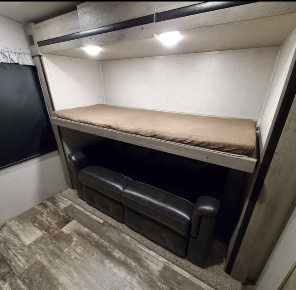 RV rental bunk bed & sofa combo optimizes space. Ideal for family adventures, offering versatile sleeping and seating.. Keystone RV Outback 2021