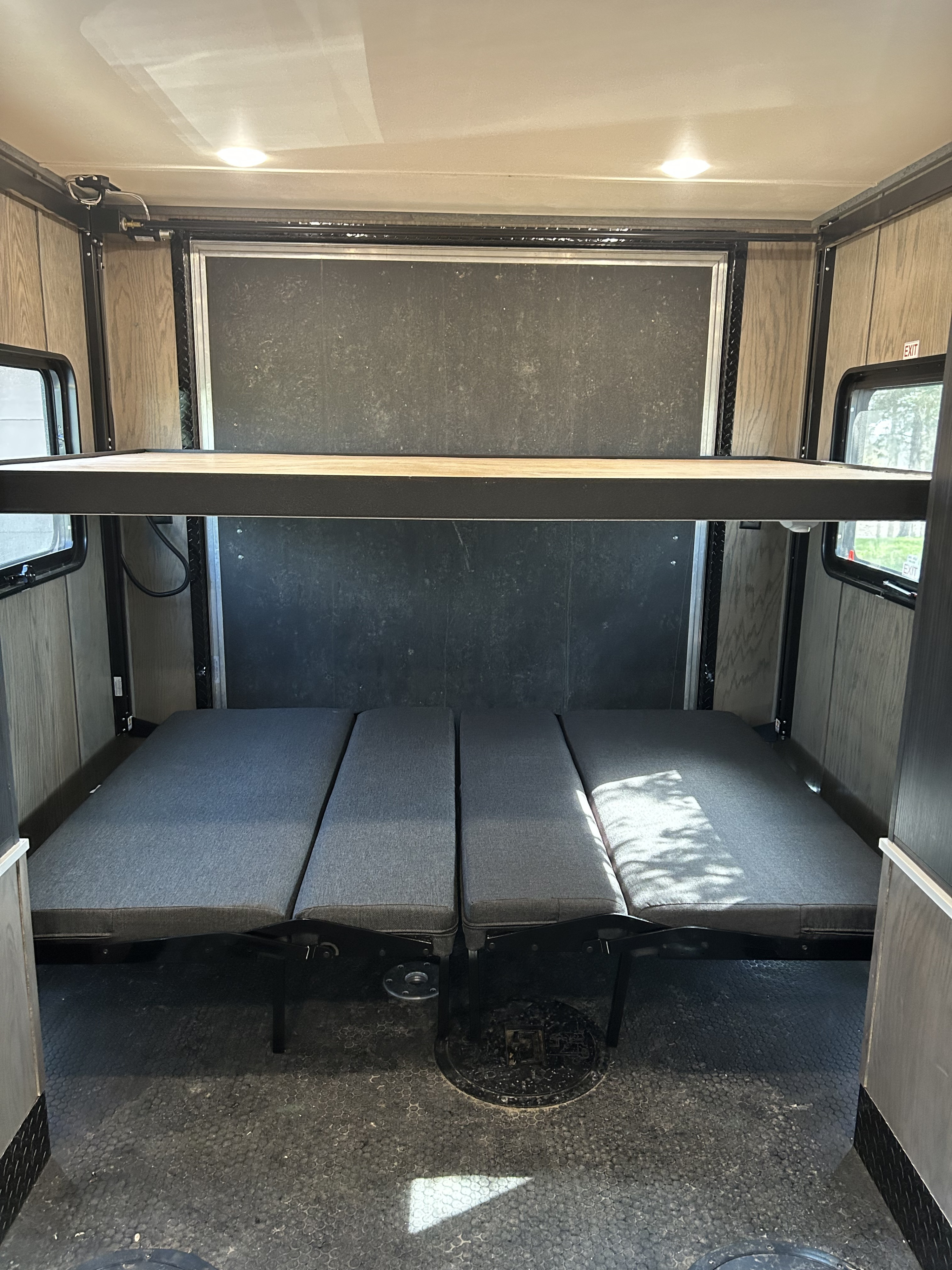RV rental interior with versatile bunk beds and four convertible lower sleeping cushions for sleeping or seating.. Team Lodge Extreme 2 2022