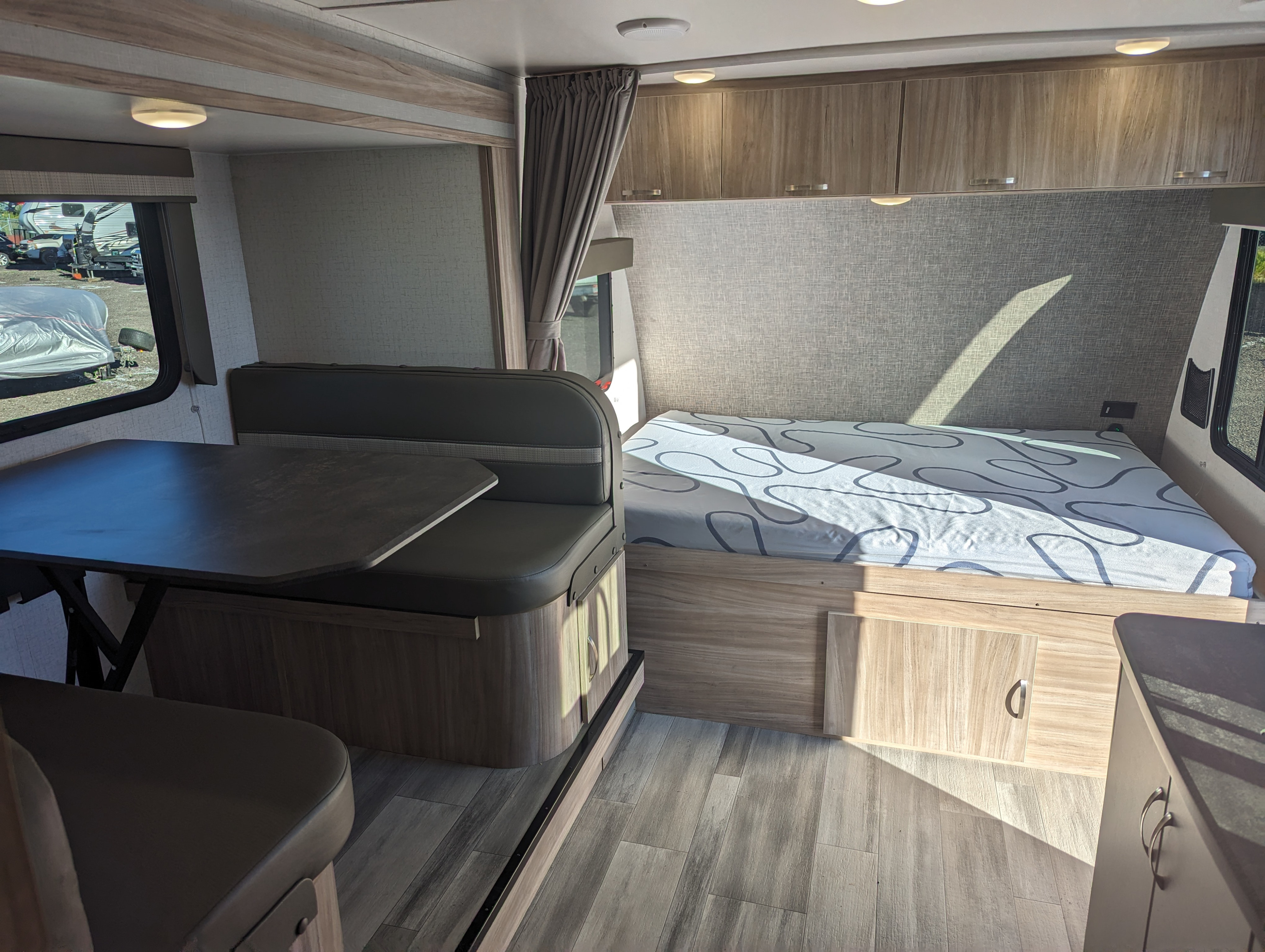 RV rental interior: Featuring a modern dinette area, comfortable bed, and ample storage, ready for your next adventure.. Winnebago Micro Minnie 2022