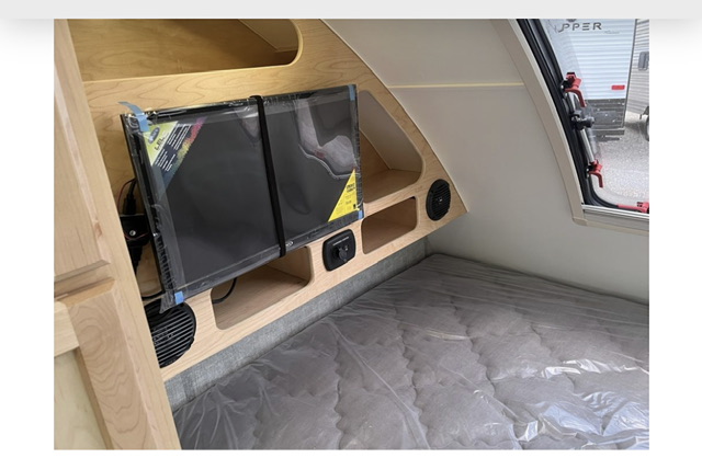 RV rental: Cozy interior featuring a wall-mounted TV, a bed with new mattress, built-in storage, and a window.. Xtreme Outdoors Xtreme Outdoors Trailer 2022