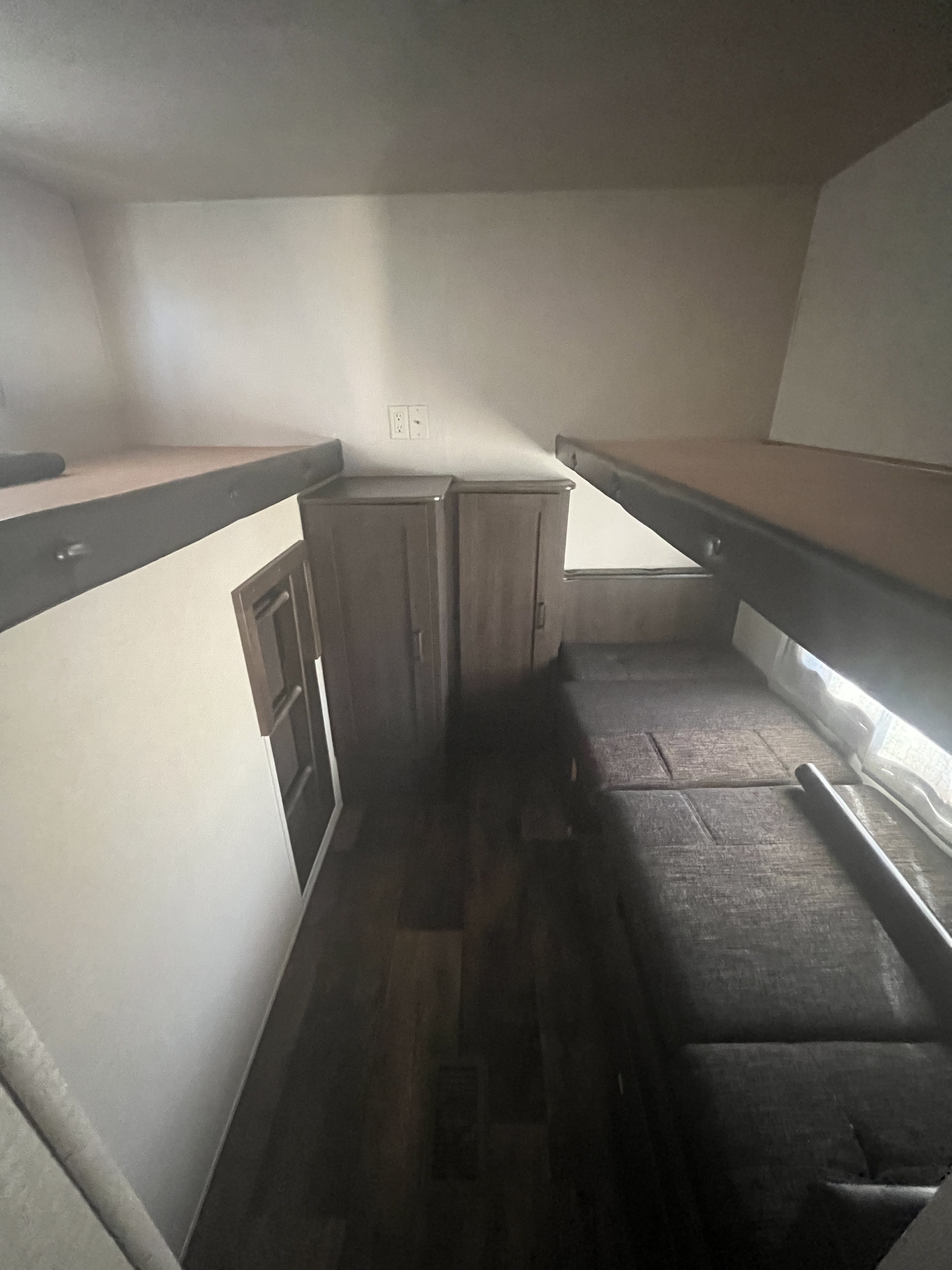Inside an RV rental, this bunk room features two elevated bunks, a lower bed, and storage. Perfect for family adventures.. Forest River Salem 2018