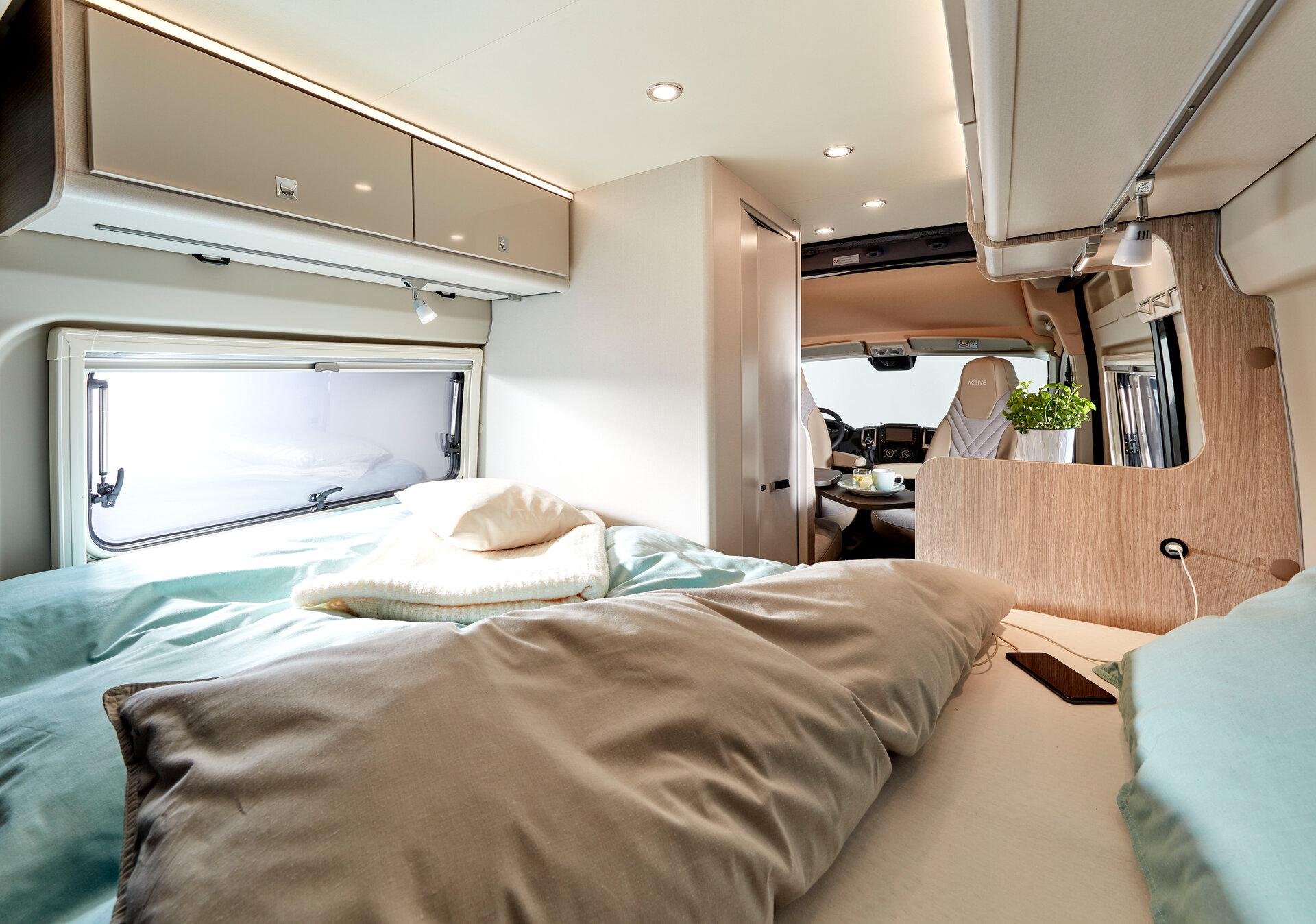 Inside a comfortable RV rental: bed, window, storage, and front cabin area. Perfect for travel adventures.. Bürstner CAMPEO 540 2023