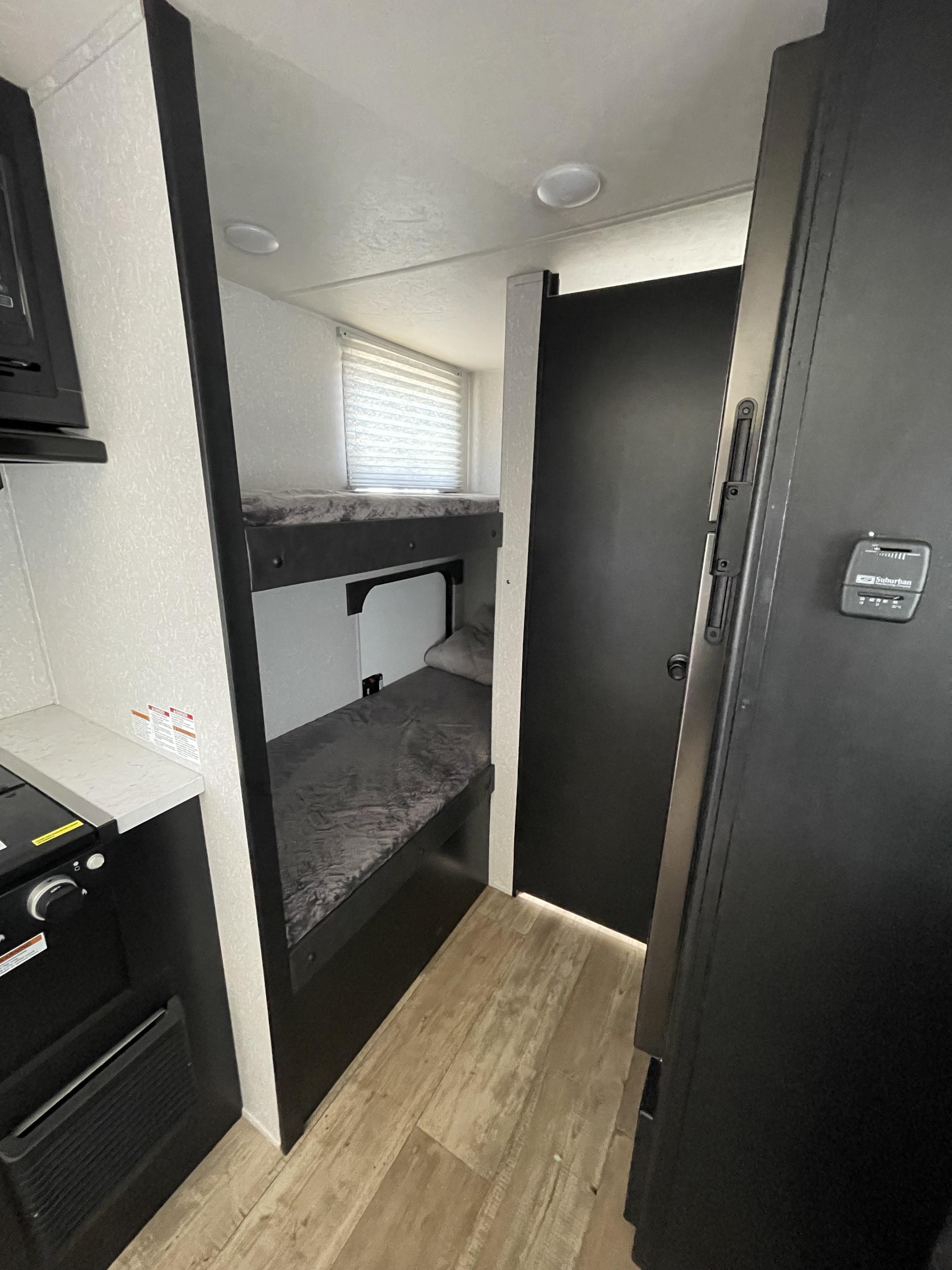 This RV rental's interior showcases cozy bunk beds, a compact kitchen counter, and a functional layout for travel.. Forest River Cherokee Wolf Pup 2022
