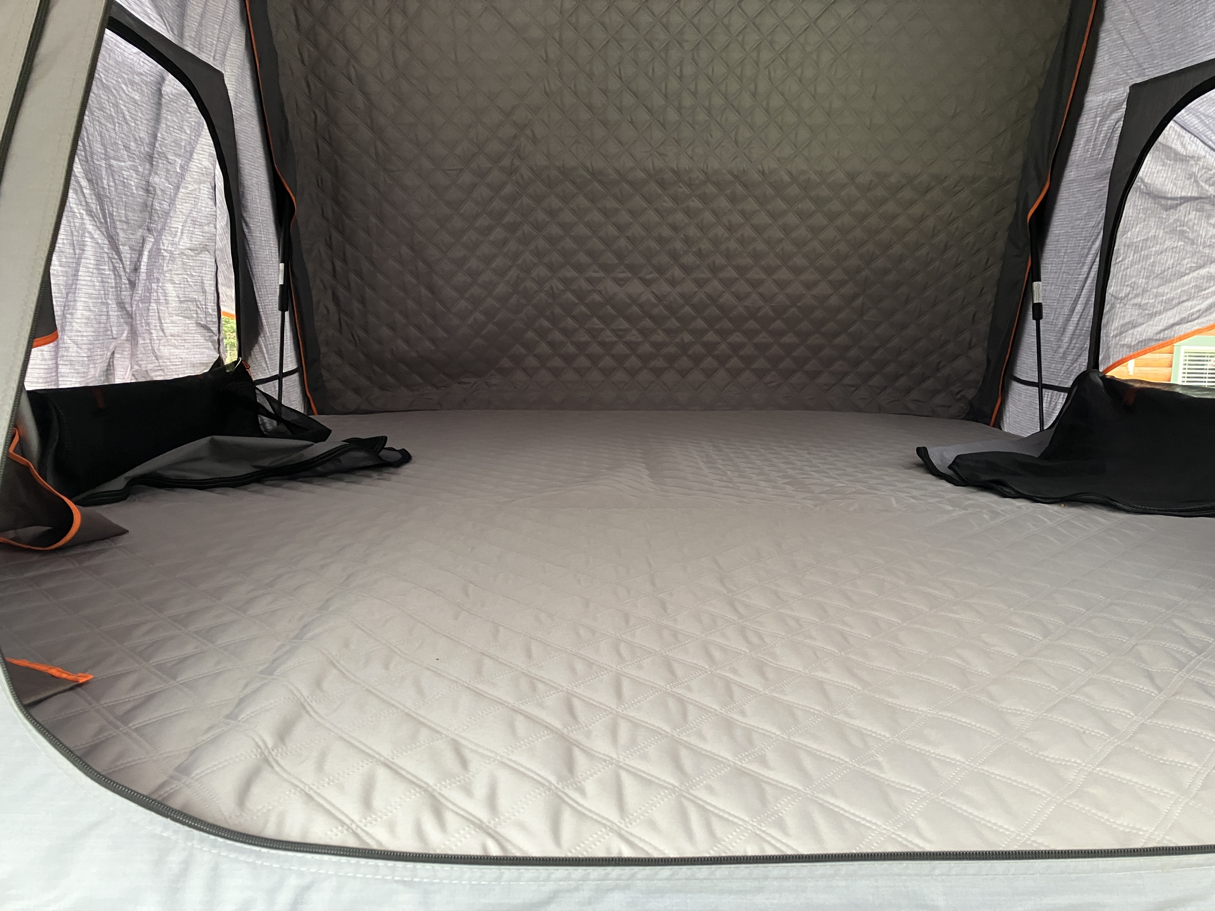 Inside a cozy RV rental: quilted mattress, dark walls, and bright windows offer a comfortable camping experience.. Toyota Dx xtracab 1994