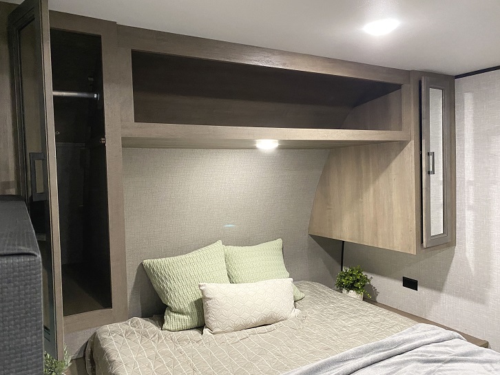 Cozy RV rental bedroom featuring a comfortable bed, overhead storage cabinets, and a convenient closet for your travels.. Jayco Wayfinder Go Play 2023