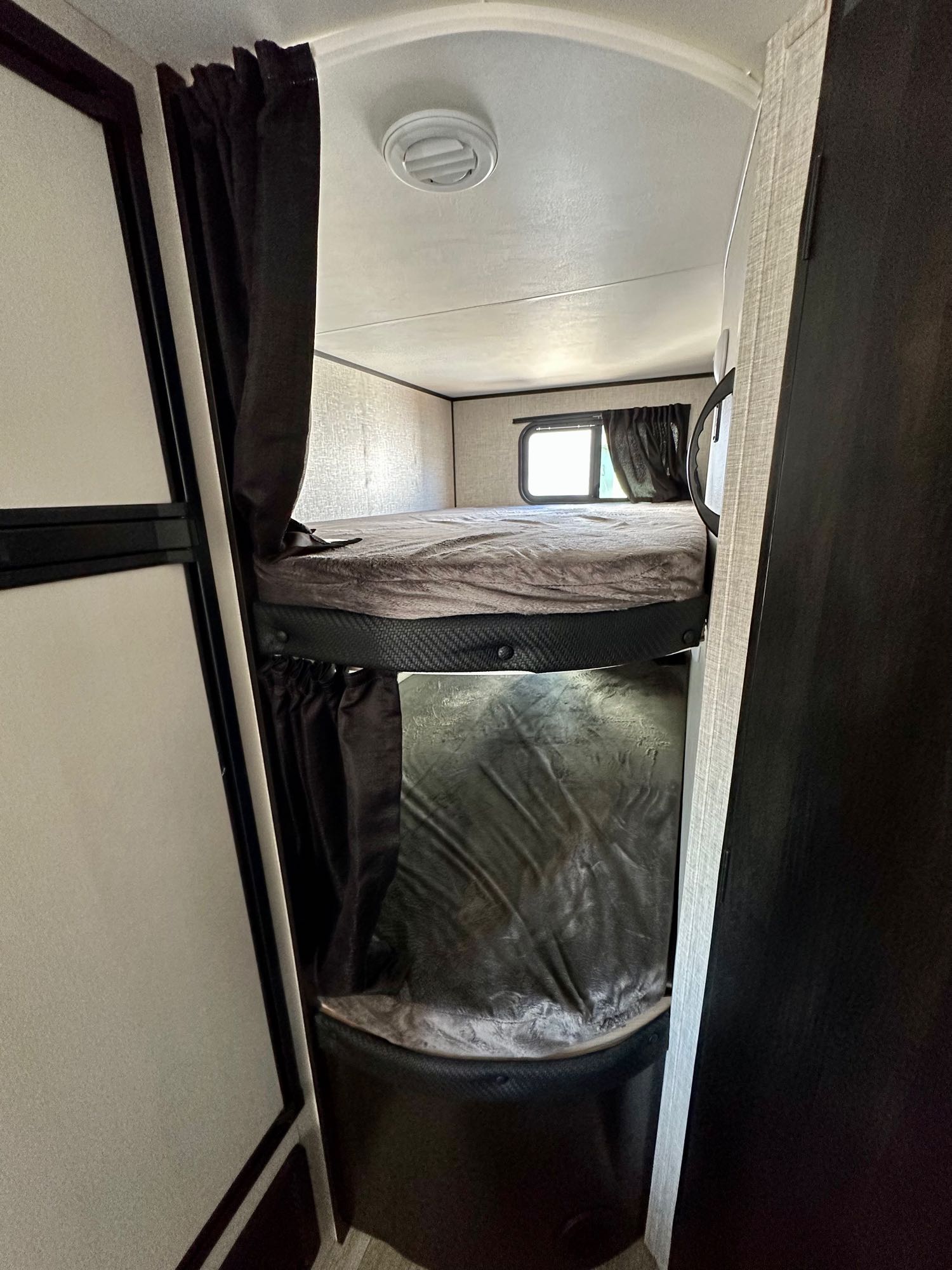 Compact RV rental interior featuring cozy bunk beds with privacy curtains, ideal for travel adventures.. Jayco Jay Flight 2023