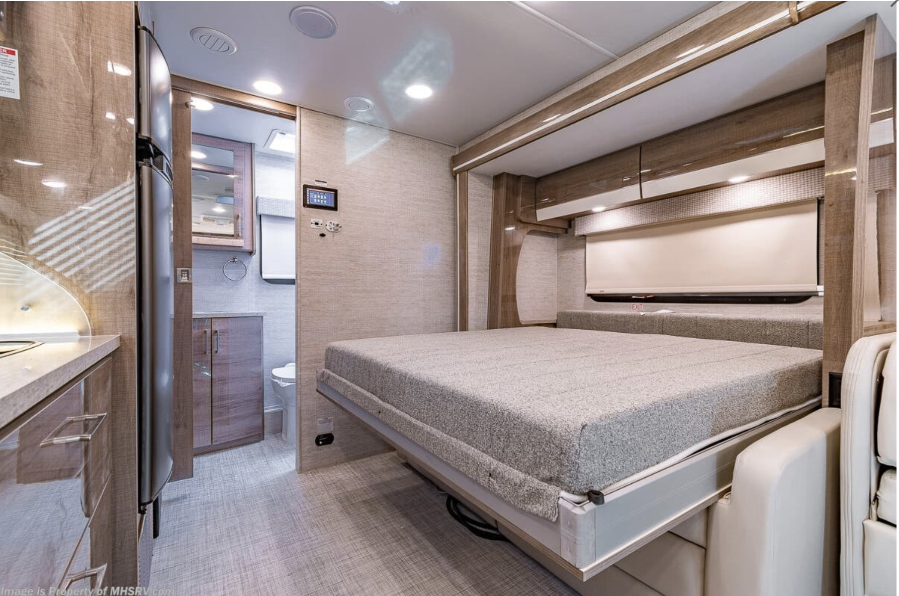 Modern RV rental interior with a space-saving fold-down bed, kitchenette, and bathroom. Perfect for comfortable travel.. Entegra Coach Qwest 2021