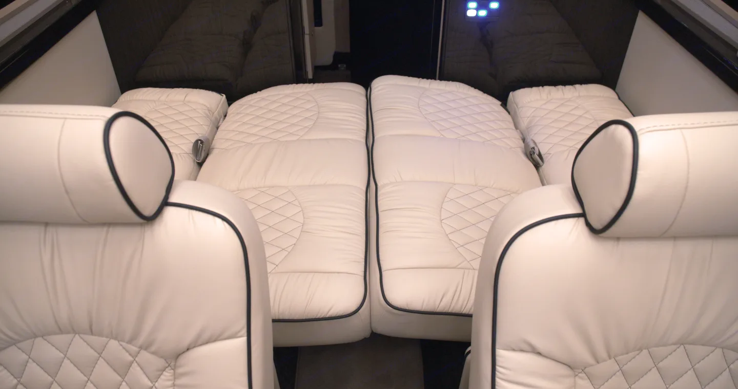 This RV rental features a premium white quilted interior with plush seats that convert into comfortable beds, ideal for trips.. Midwest Automotive Designs Ultimate Presidential 2021