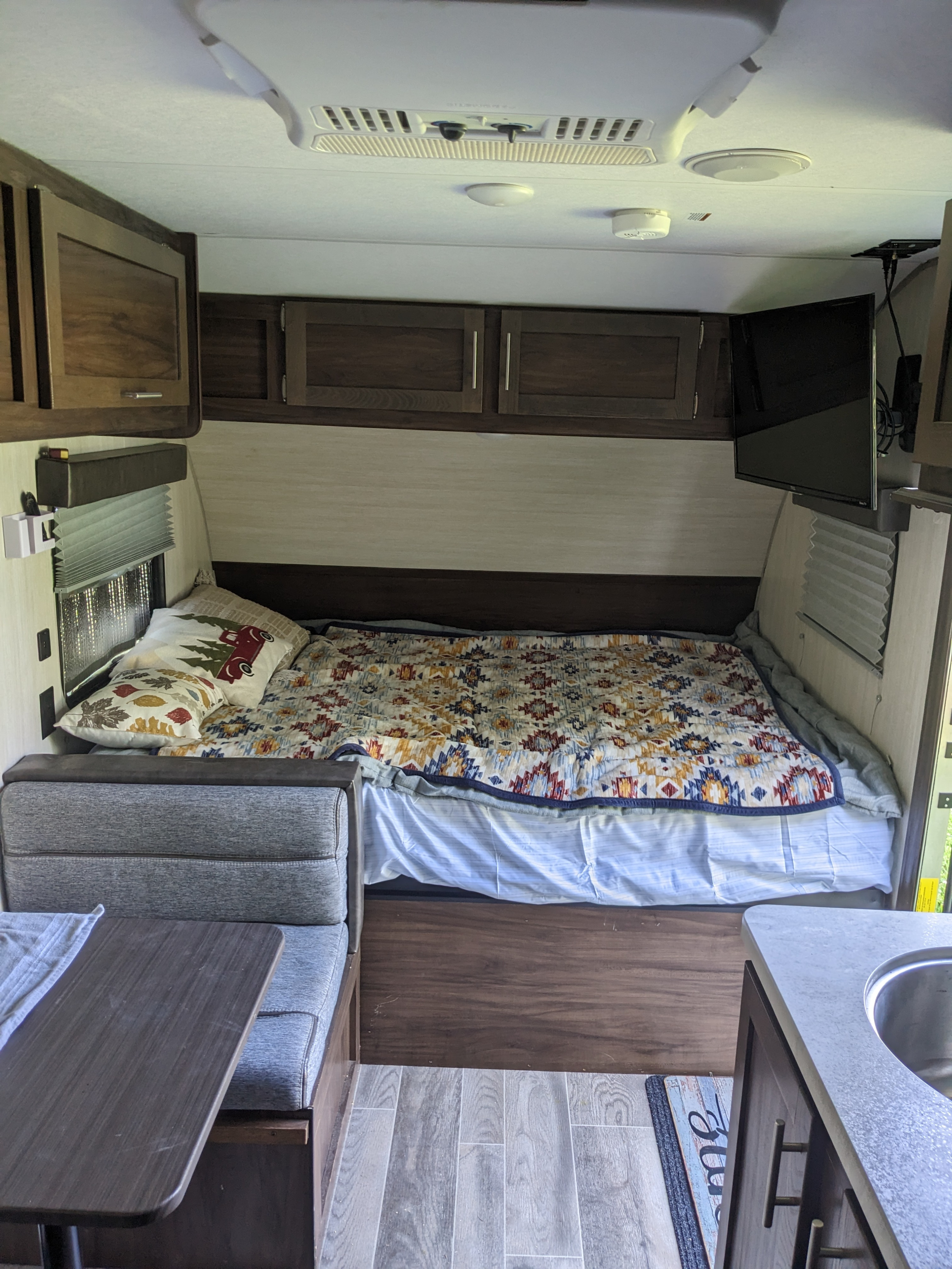 RV rental living space: view of a bed, small dinette, and kitchen counter with sink.. Forest River Cherokee Wolf Pup 2019