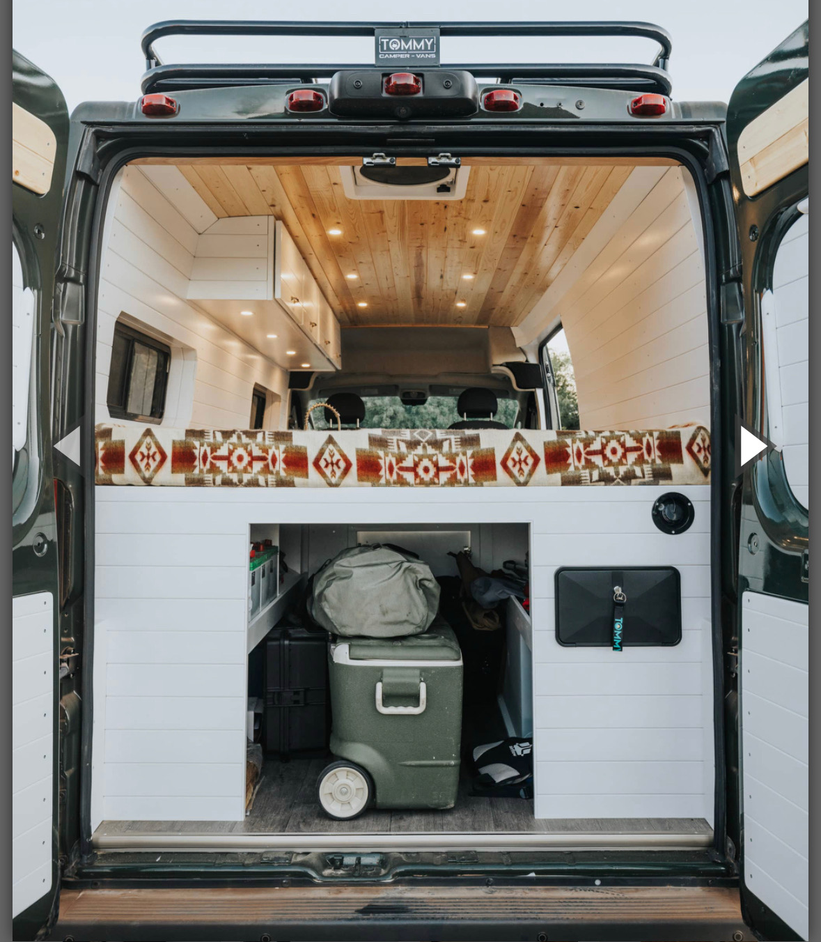 rv rental camper van interior. Cozy raised bed with patterned blanket, clever storage area below for gear & cooler.. Ram Promaster 2500 Promaster 2500 2018