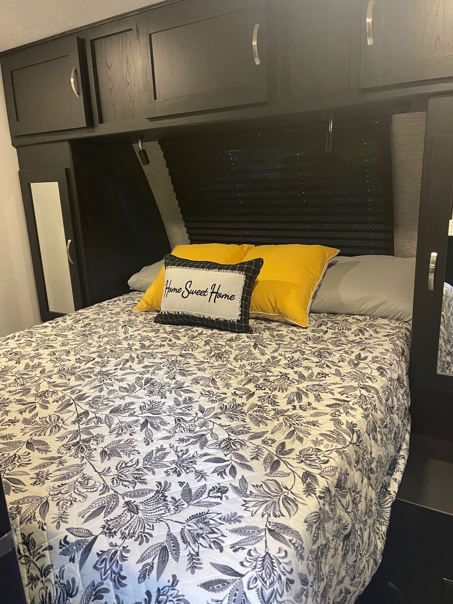 Cozy RV rental bedroom with a floral comforter, "Home Sweet Home" pillow, and built-in storage, perfect for travel.. Coachmen Freedom Express 2022