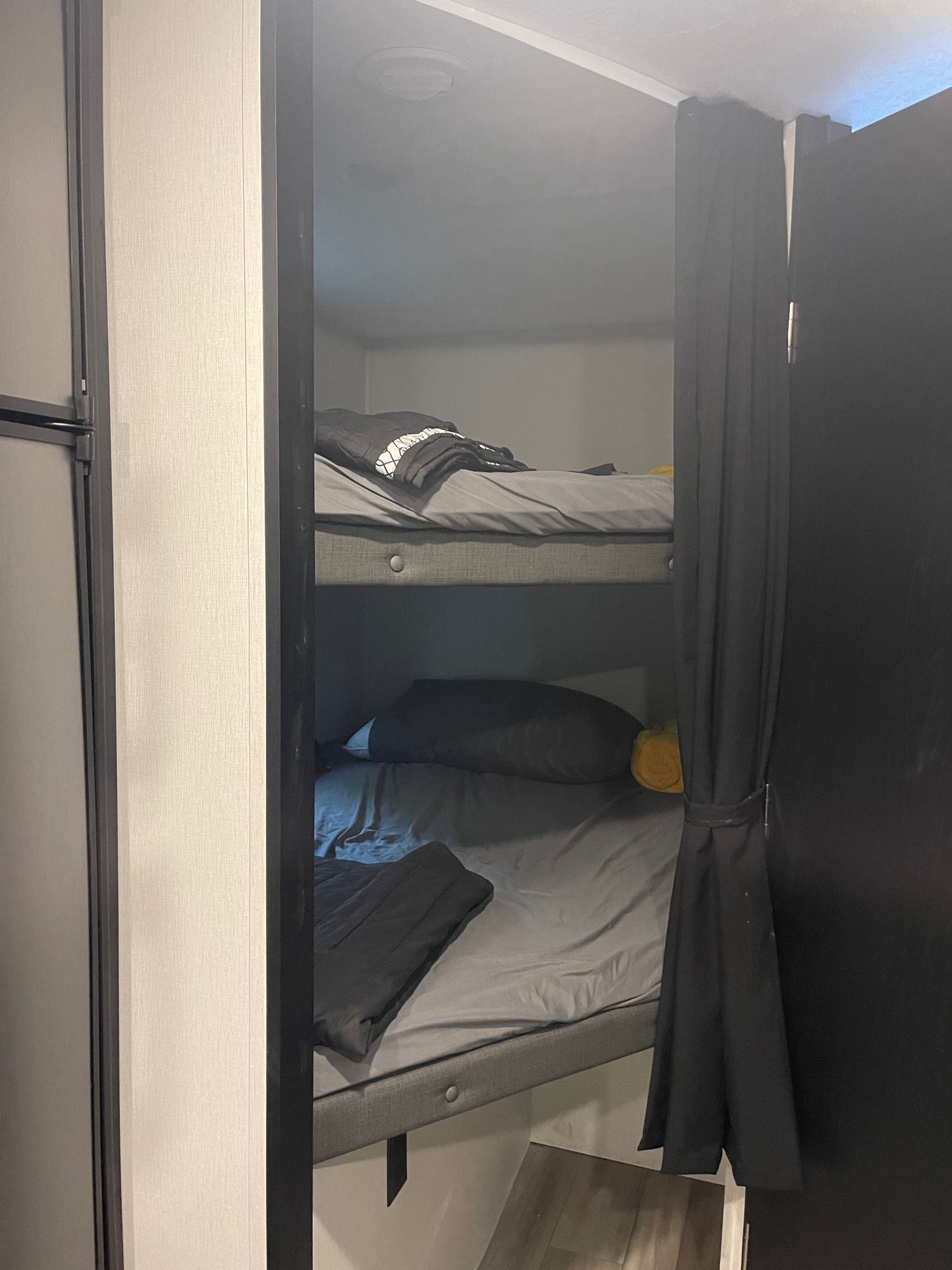 RV rental's bunk beds: two levels with grey bedding & black curtains for privacy.. Coachmen Freedom Express 2022