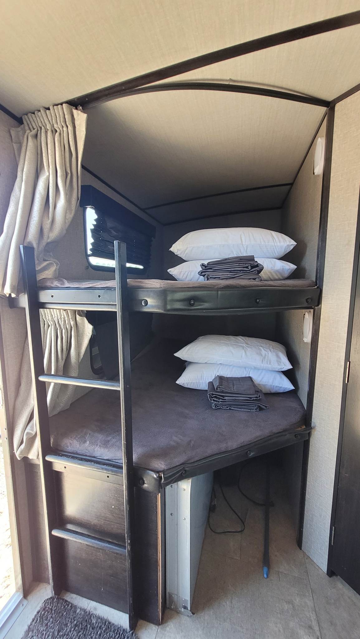 Comfortable bunk beds with fresh linens inside an RV rental. Perfect for families on a trip.. Grand Design Imagine 2018