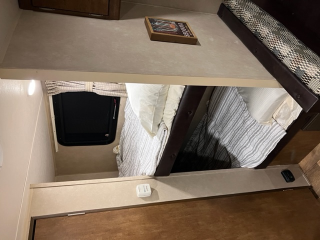 RV rental: Cozy bunk beds with striped bedding & window in a compact sleeping area. Features shelf & framed art.. Forest River Wildwood 2017
