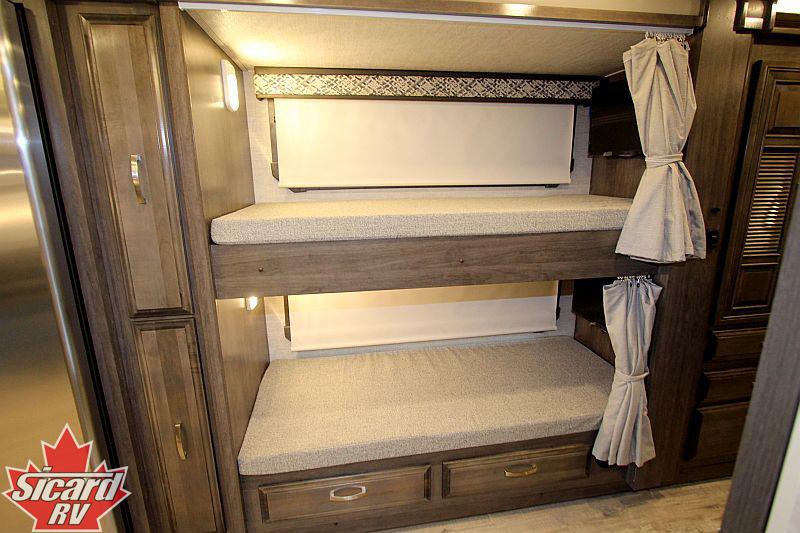 RV rental interior: two modern bunk beds feature privacy curtains, individual lighting, and under-bed storage drawers.. Jayco Seneca 2022