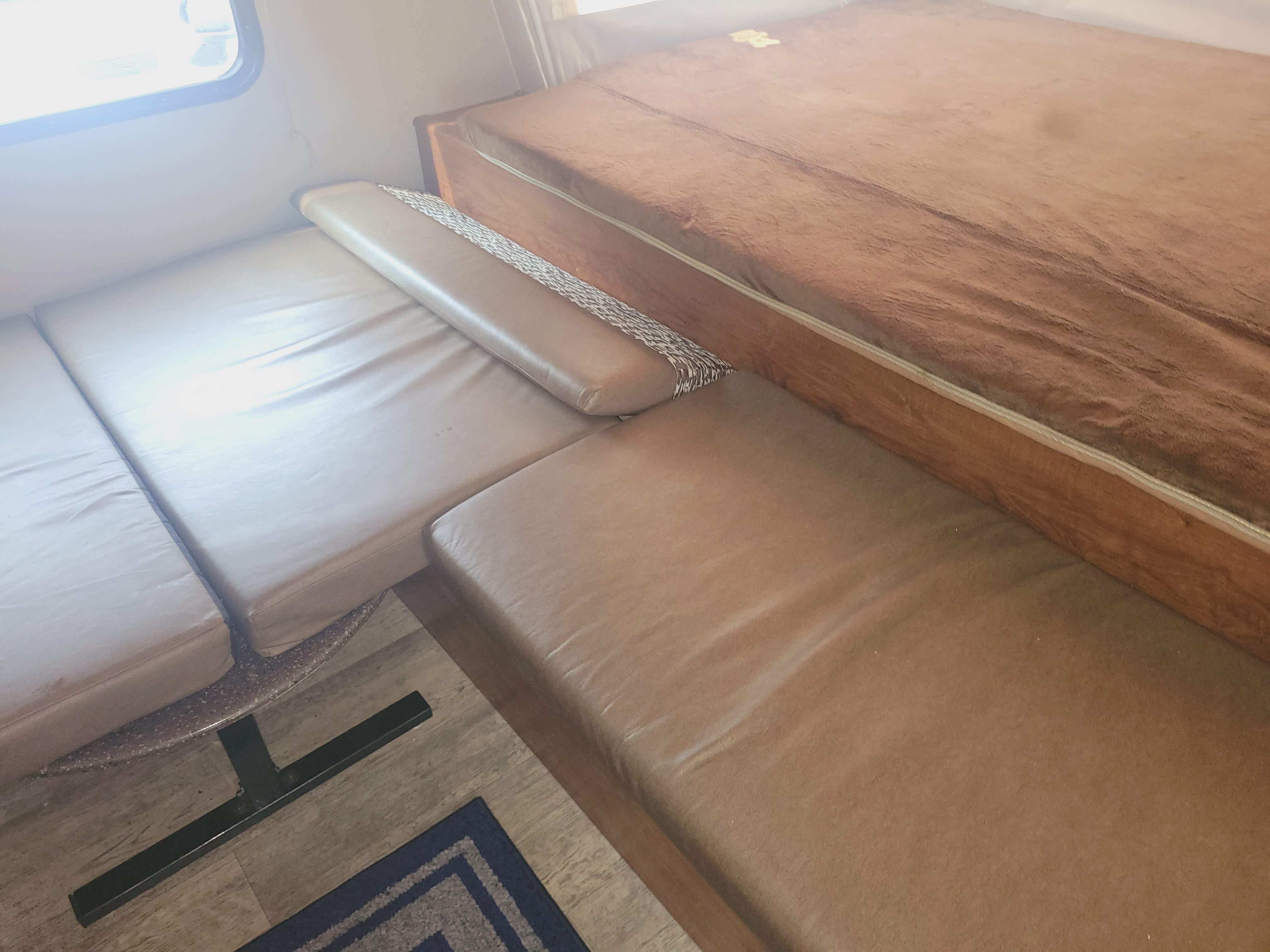 RV rental interior: Cozy tan seating/beds, featuring patterned backrest and window. Perfect for road trips!. Coachmen Freedom Express Hybrid 2018