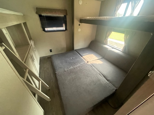 Inside an RV rental: a flexible sleeping area with bunk beds, convertible sofa, and storage for your trip.. Forest River Coachmen Aurora 2023