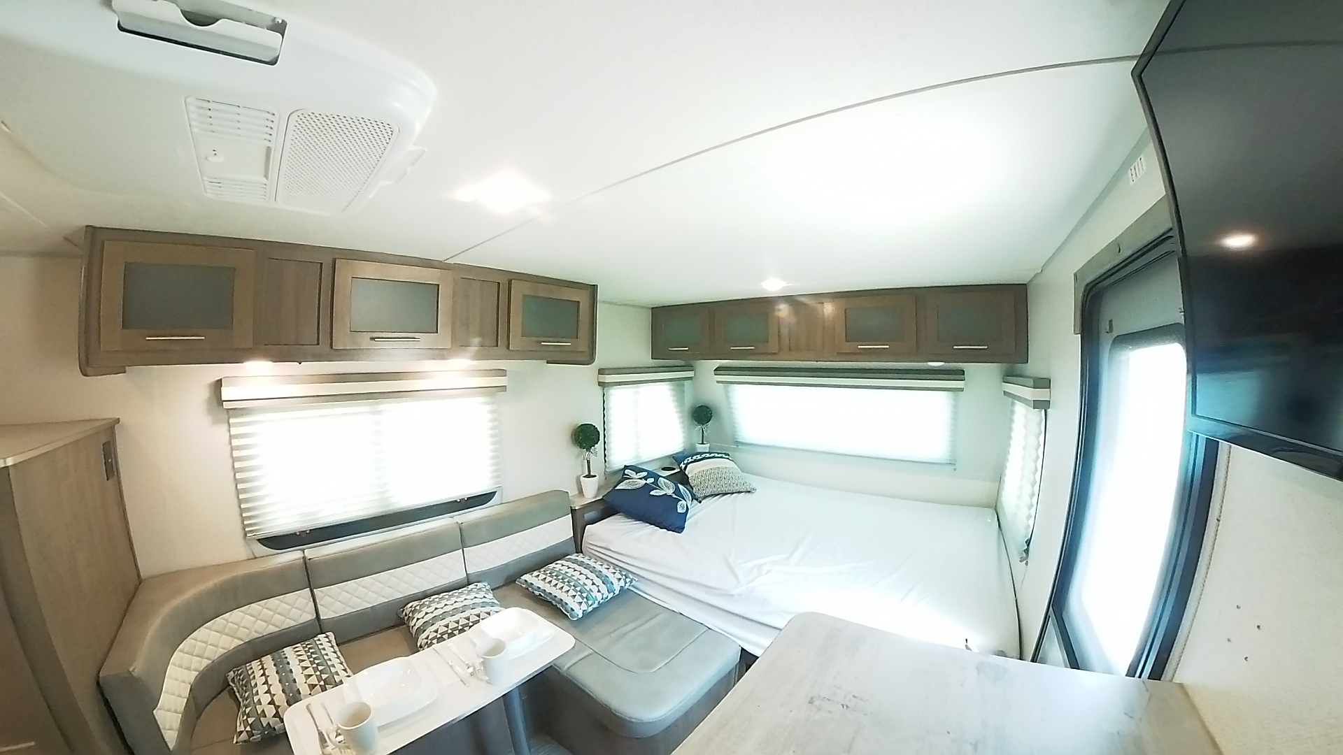 Spacious RV rental interior with a bed, dinette, overhead cabinets, and a TV for comfortable travel.. Forest River Other 2019