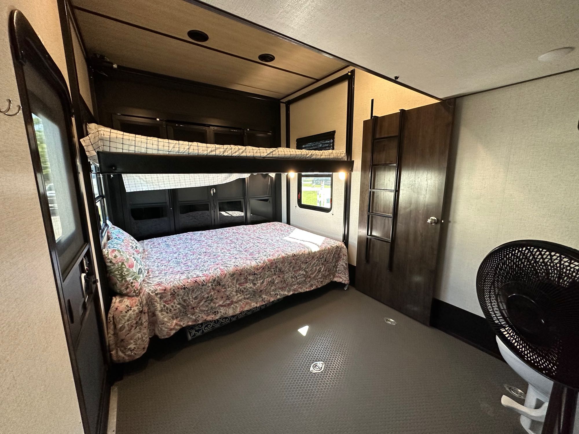 RV rental shows a bunk over queen bed setup, wardrobe, and fan in a spacious interior, ideal for family travel.. Dutchmen Voltage Triton 4172 2022