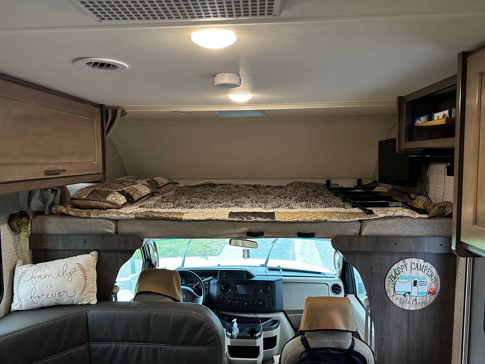 Spacious RV rental interior featuring a cozy cab-over bunk bed, front cockpit, and a comfortable seating area.. Winnebago Minnie Winnie 2020